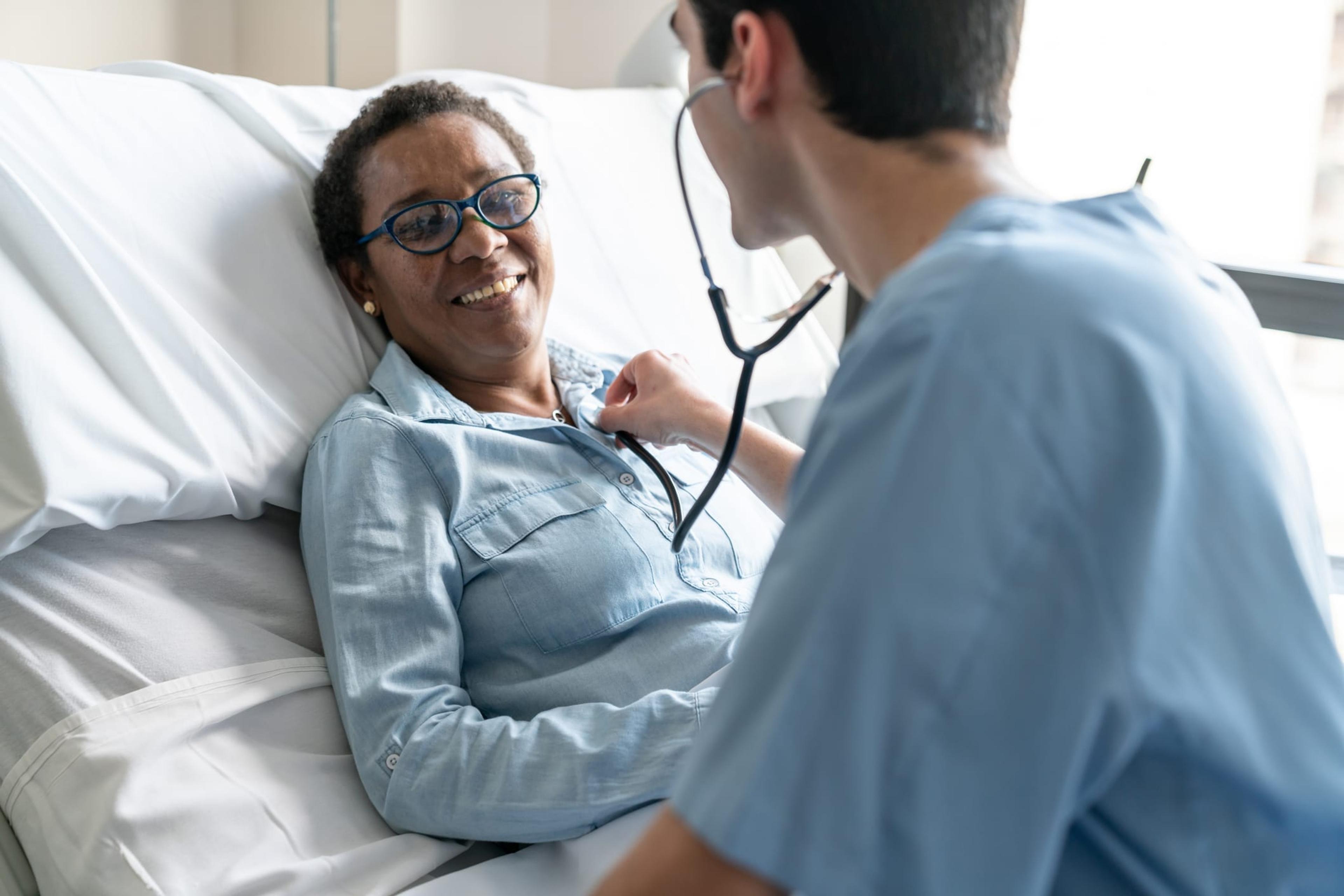 Nurse listens to female patient's heart using a stethoscope