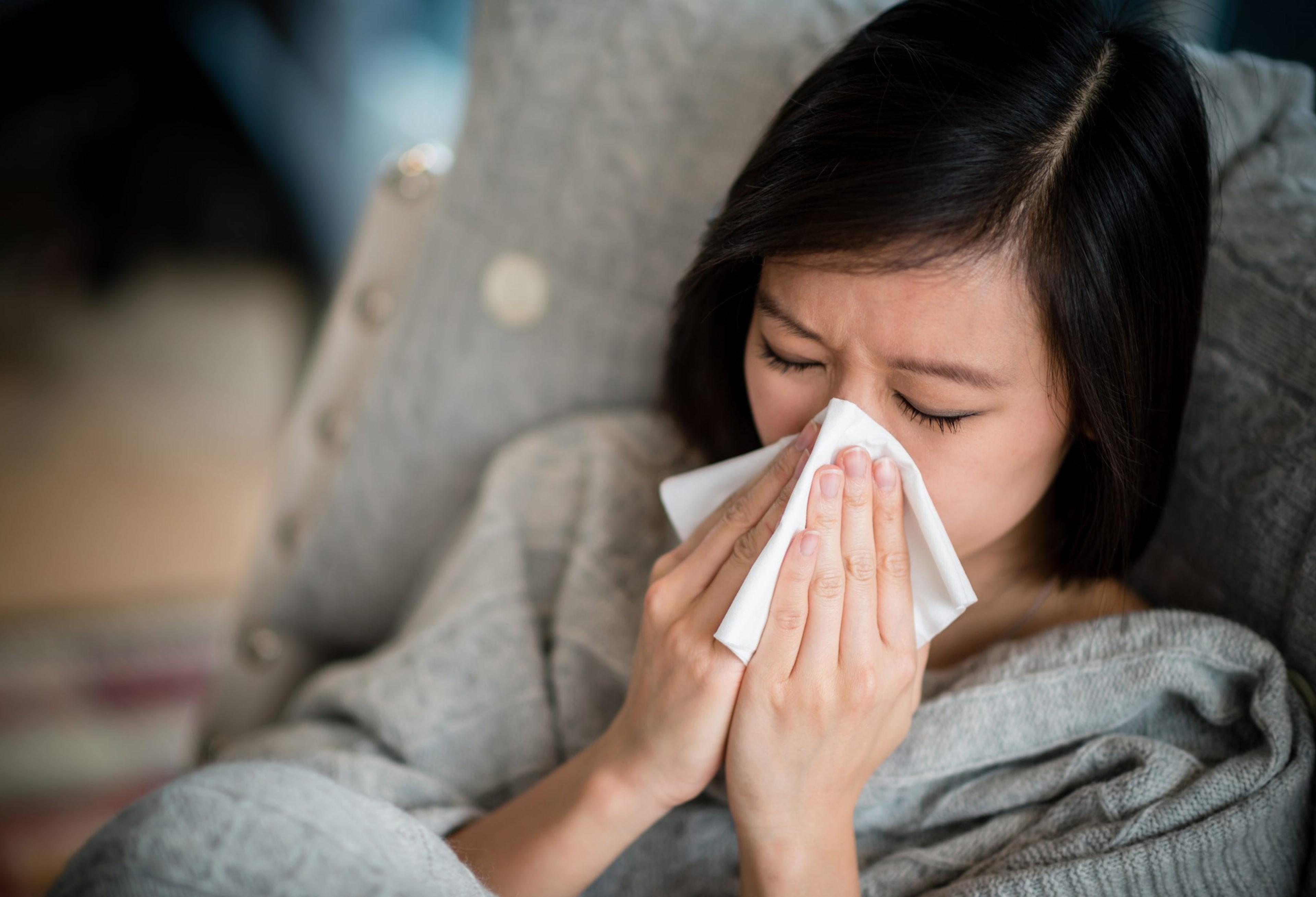 Sick woman blowing her nose.