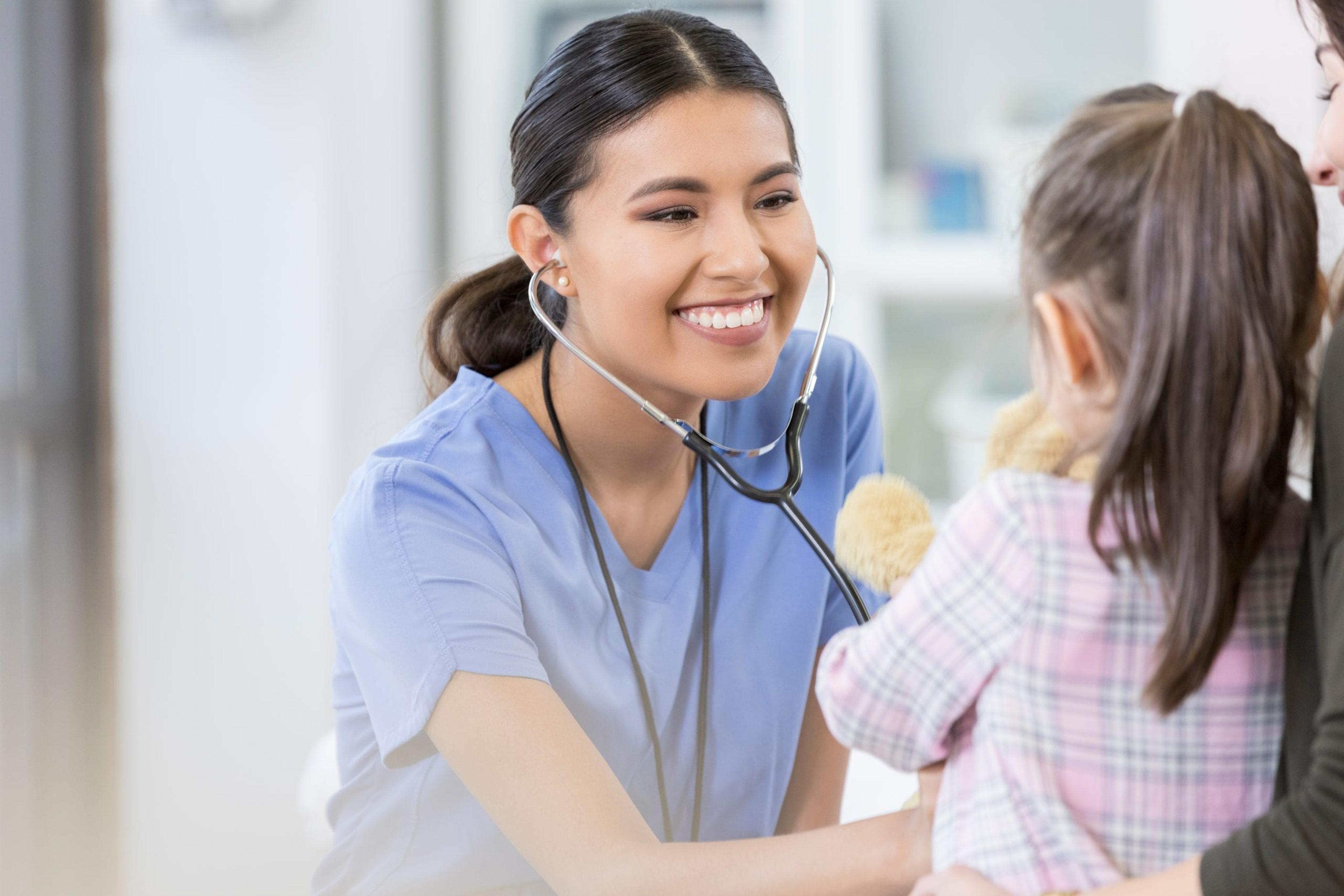 Nurse listening to a little girl's heartbeat.