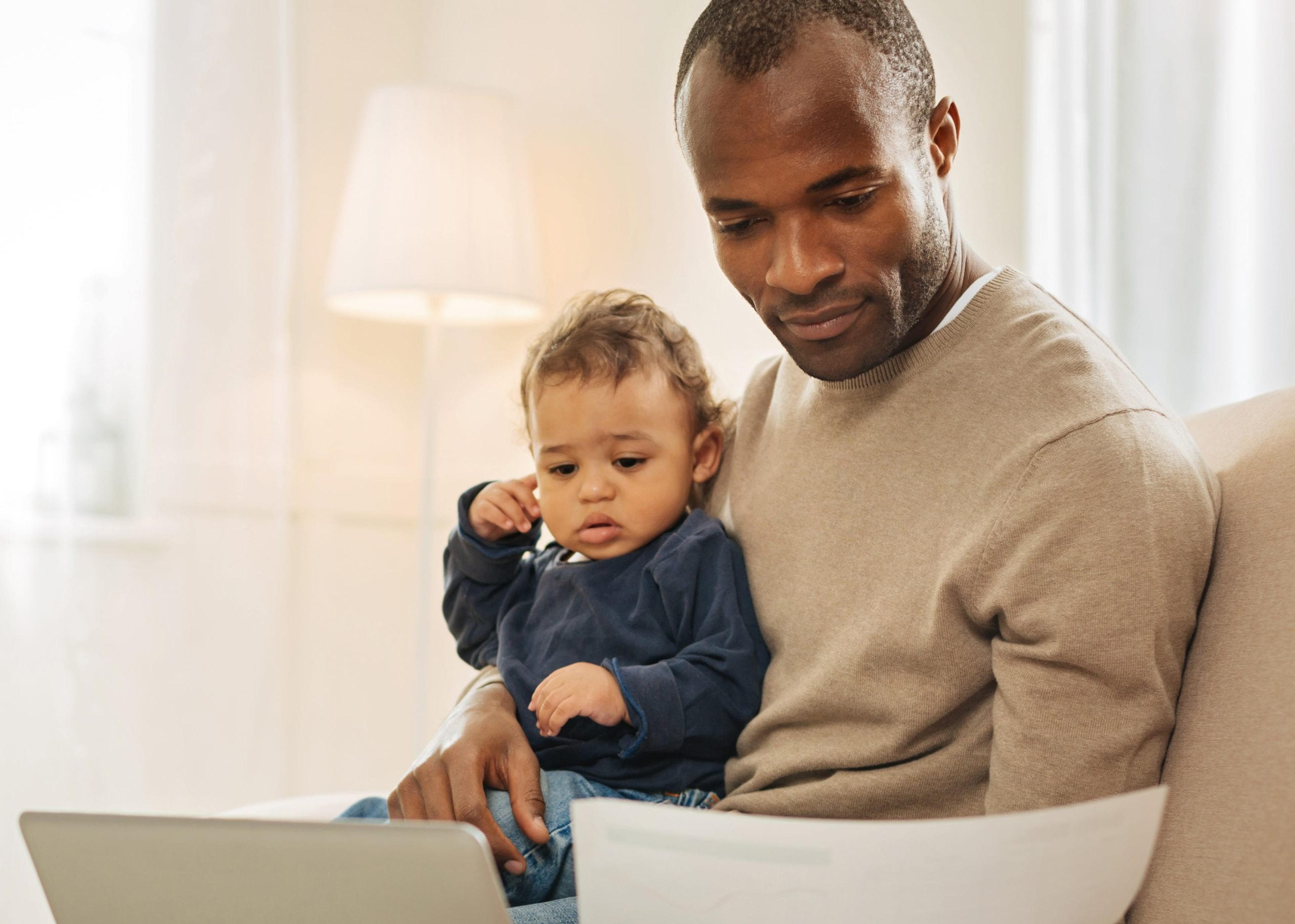 Black Man and Son With Laptop and Papers