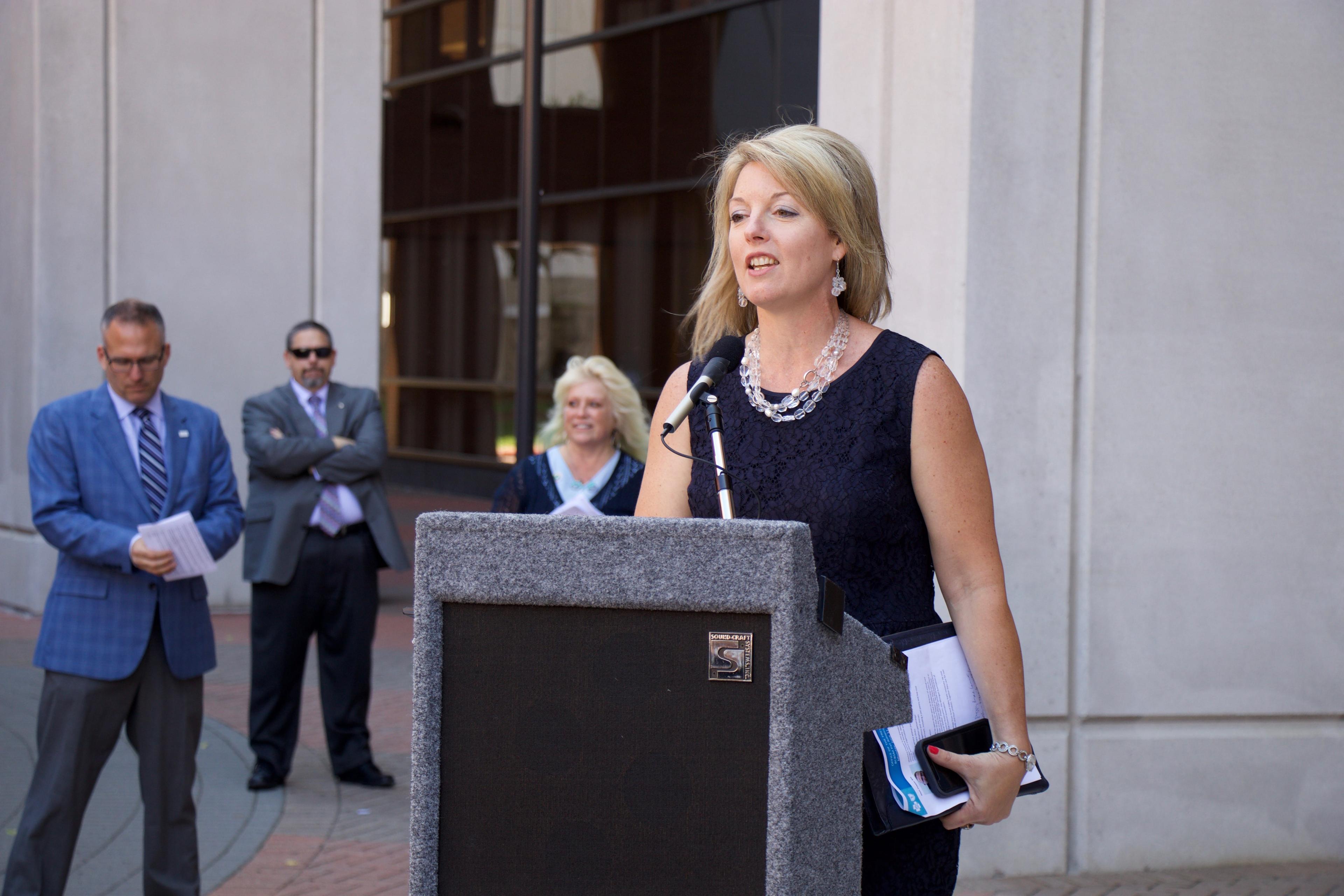 Image of Tricia Keith speaking at a 2018 Michigan Humane Society adoption event at Blue Cross Blue Shield of Michigan's Detroit campus.