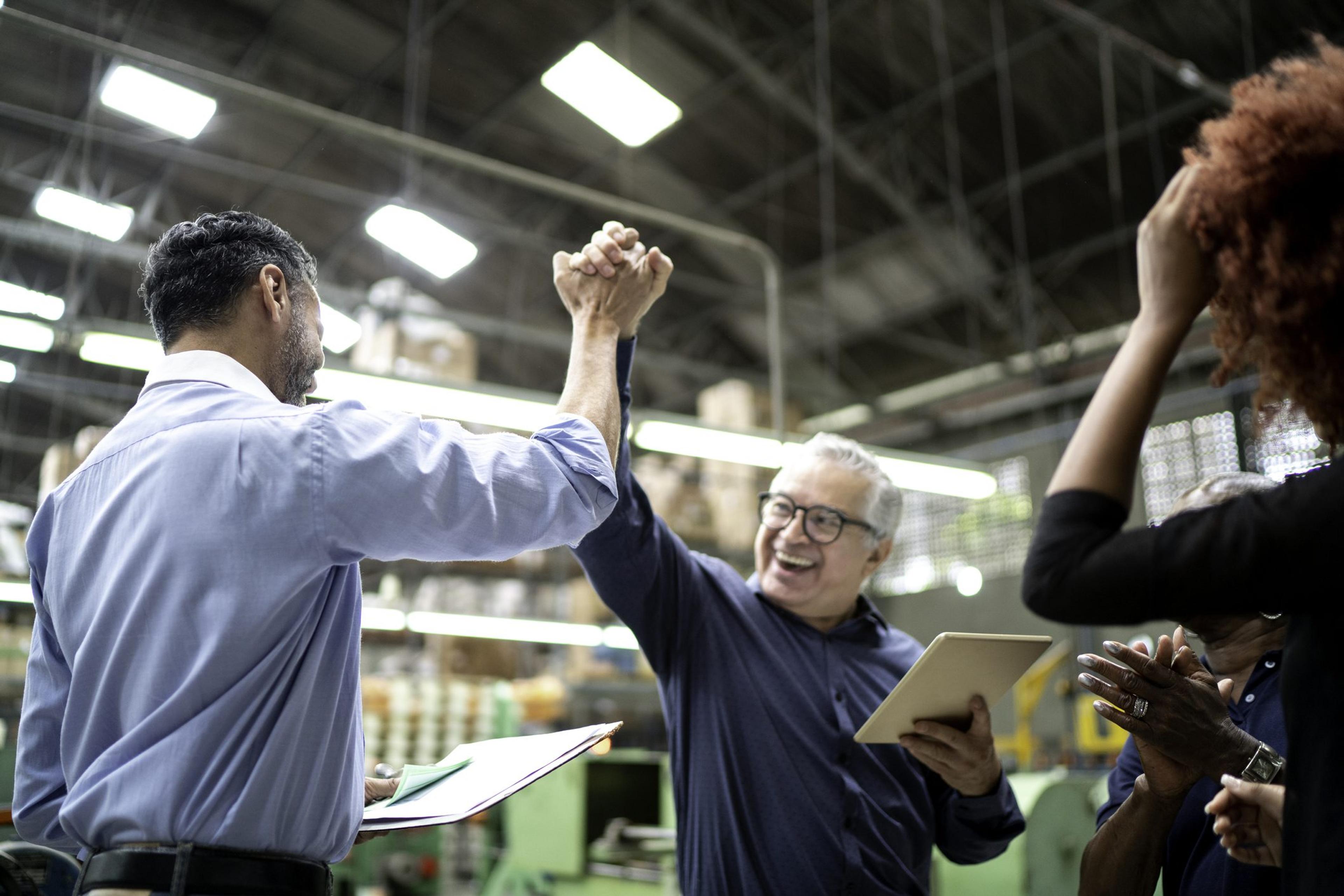 Coworkers celebrating some good news in a factory