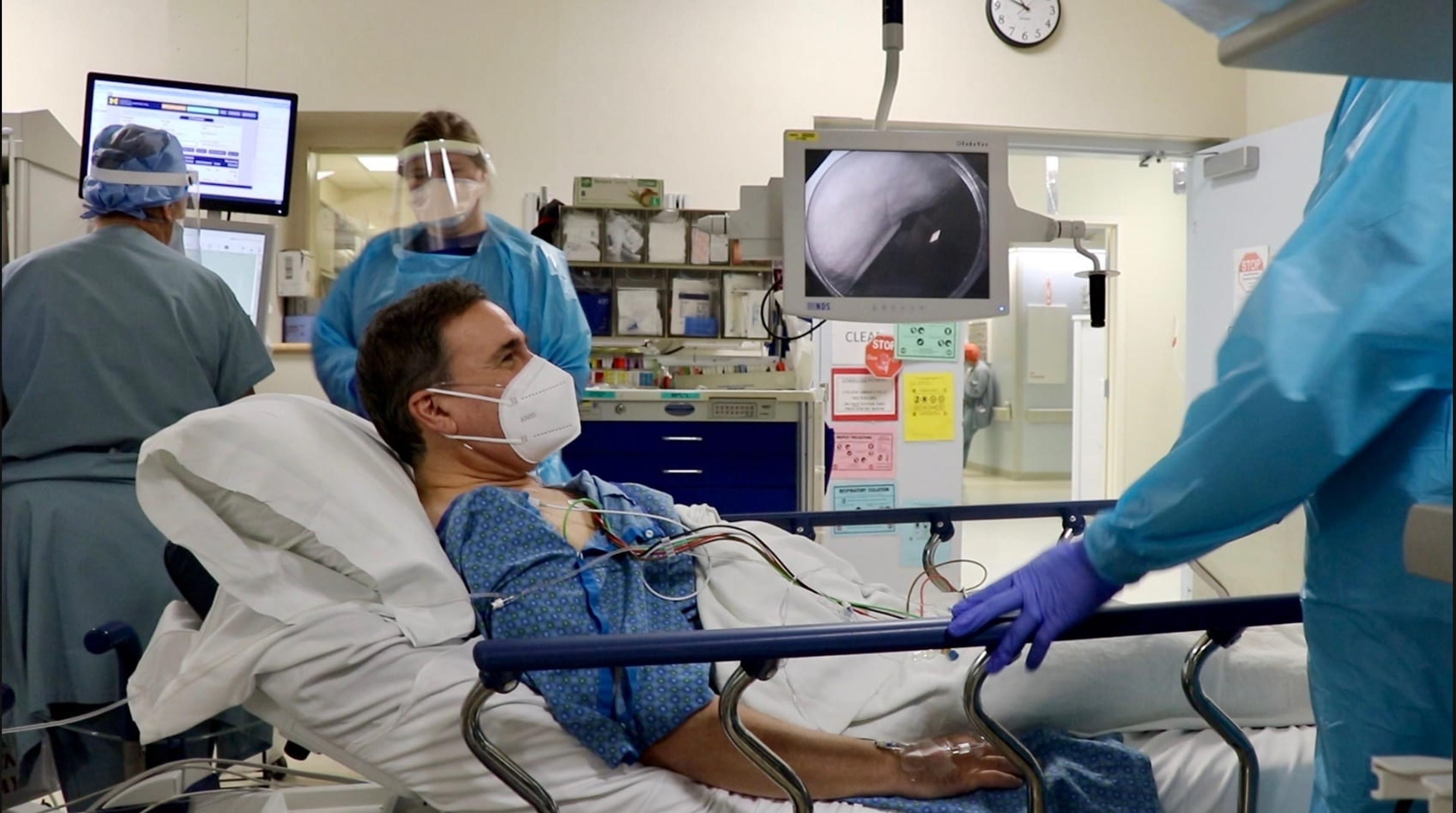 Dr. Jim Grant prepares for a colonoscopy procedure in a medical room.