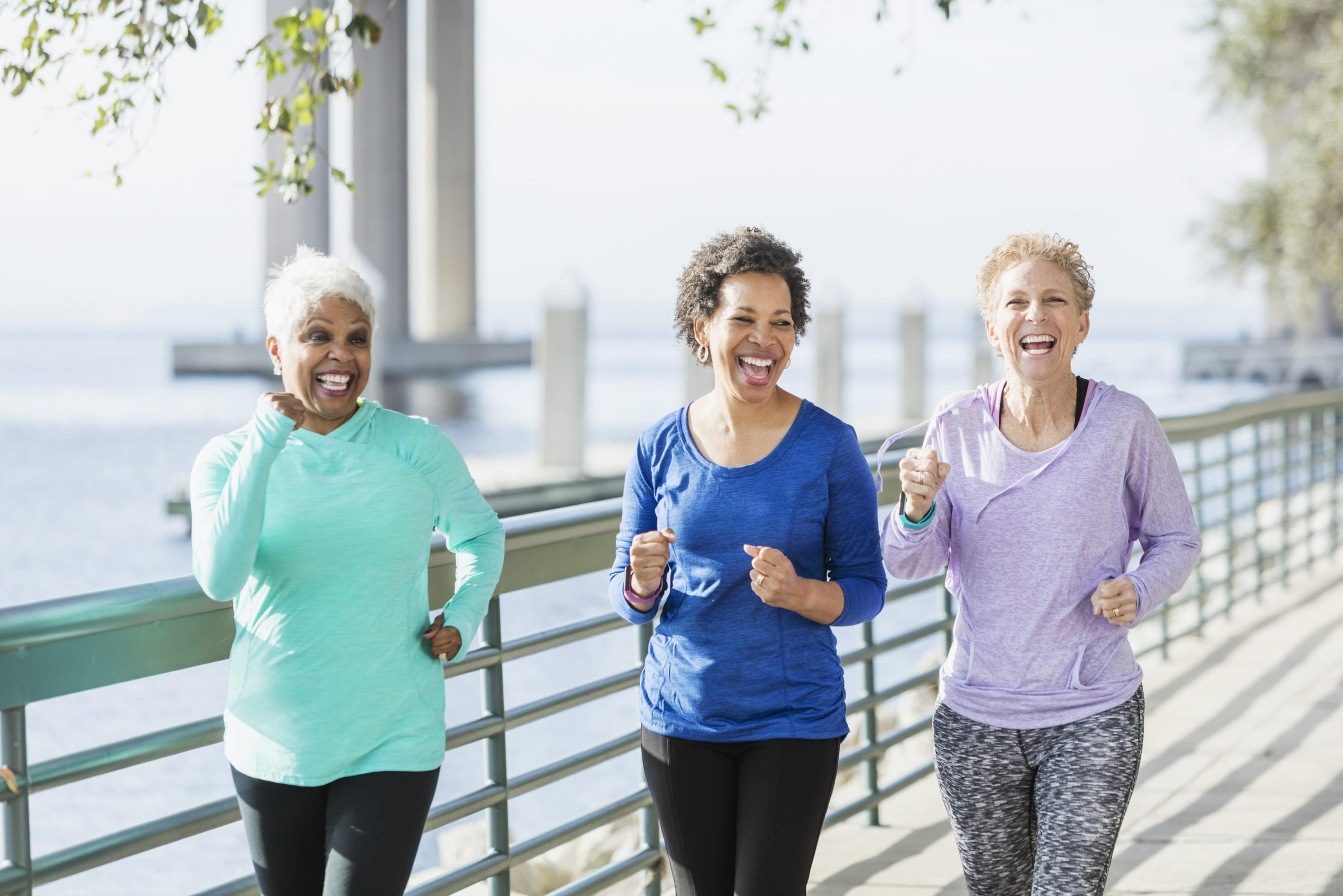 Three women walking on riverfront, laughing