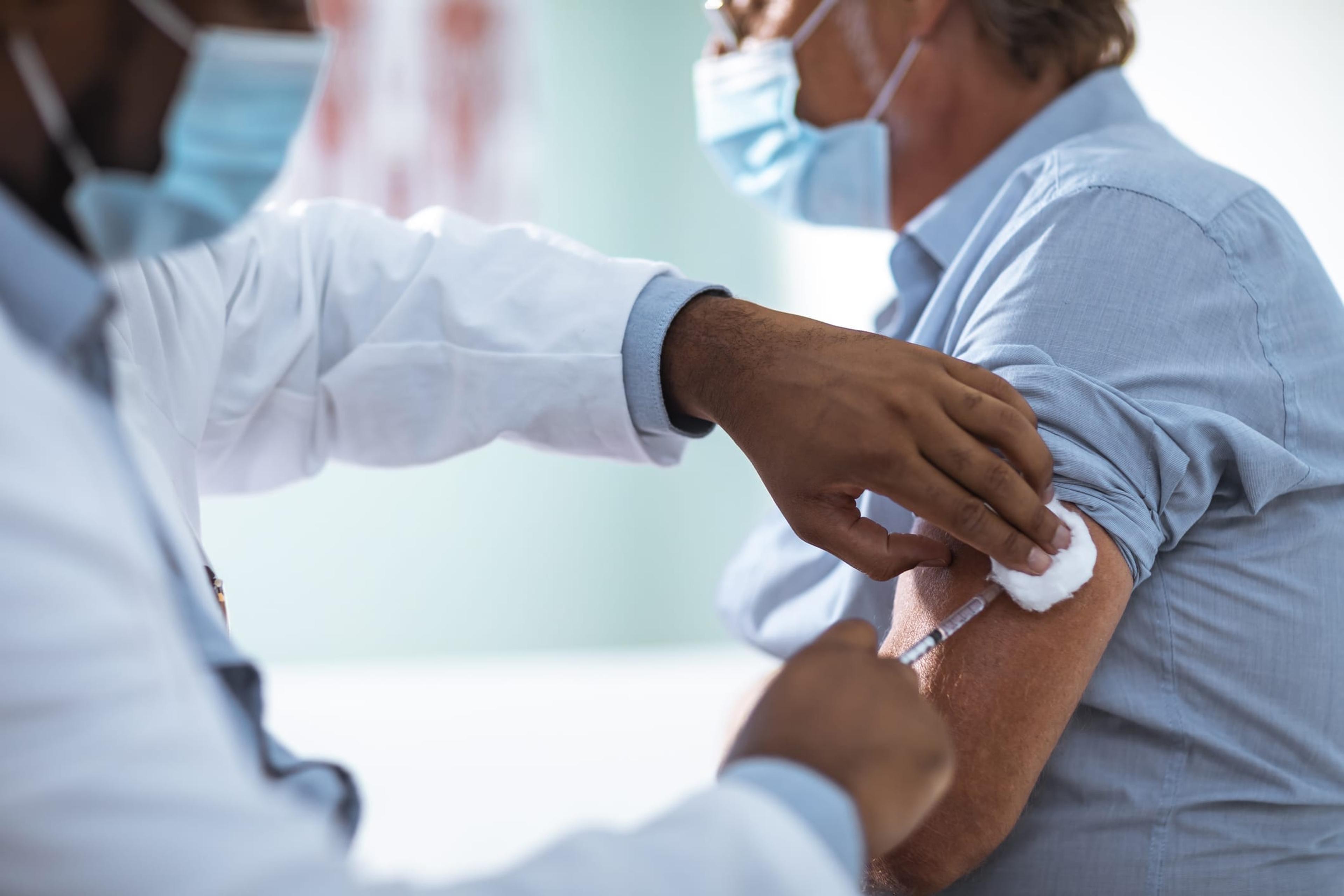 Mature man receiving a vaccine from his doctor