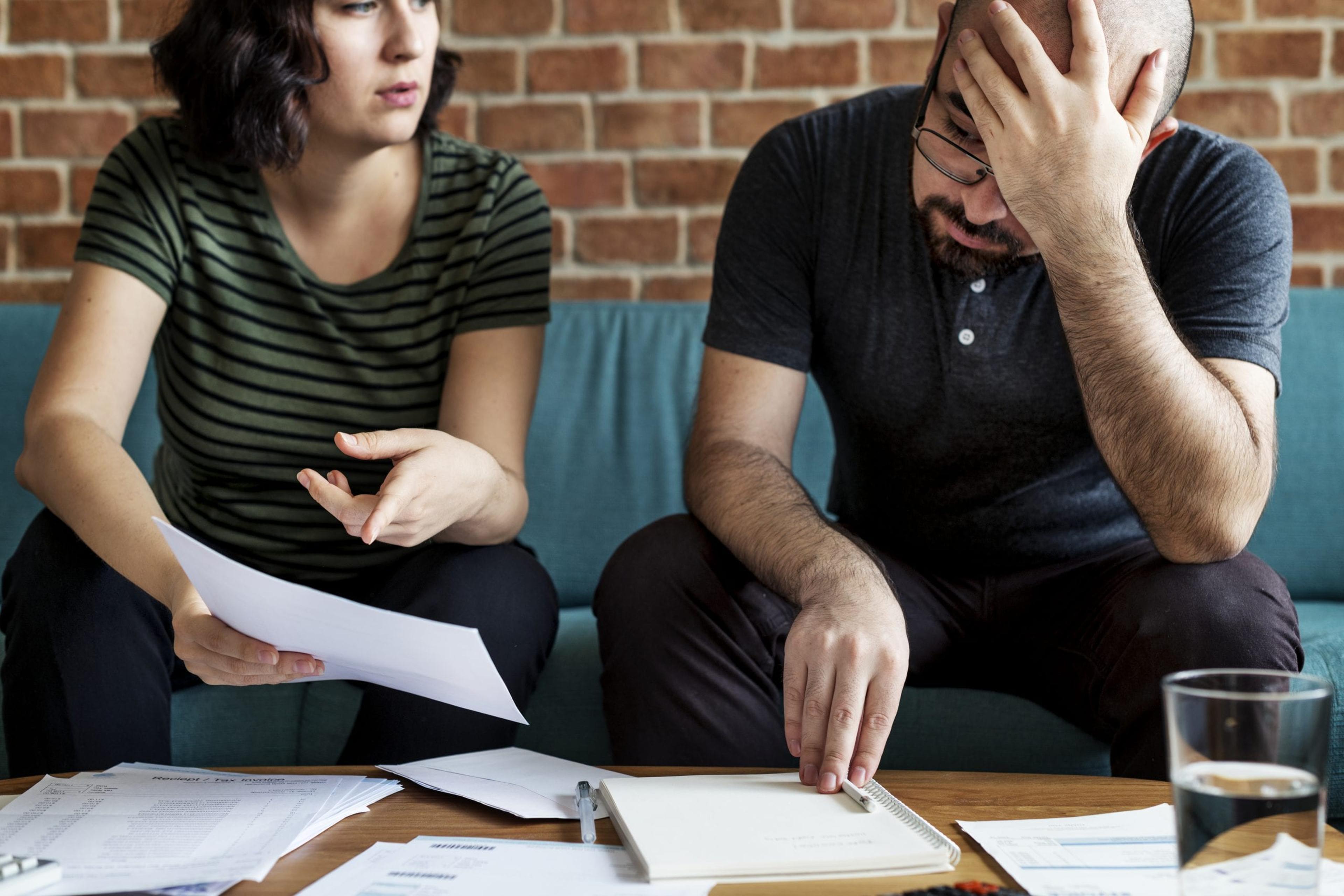 Image of a couple stressing over bills.