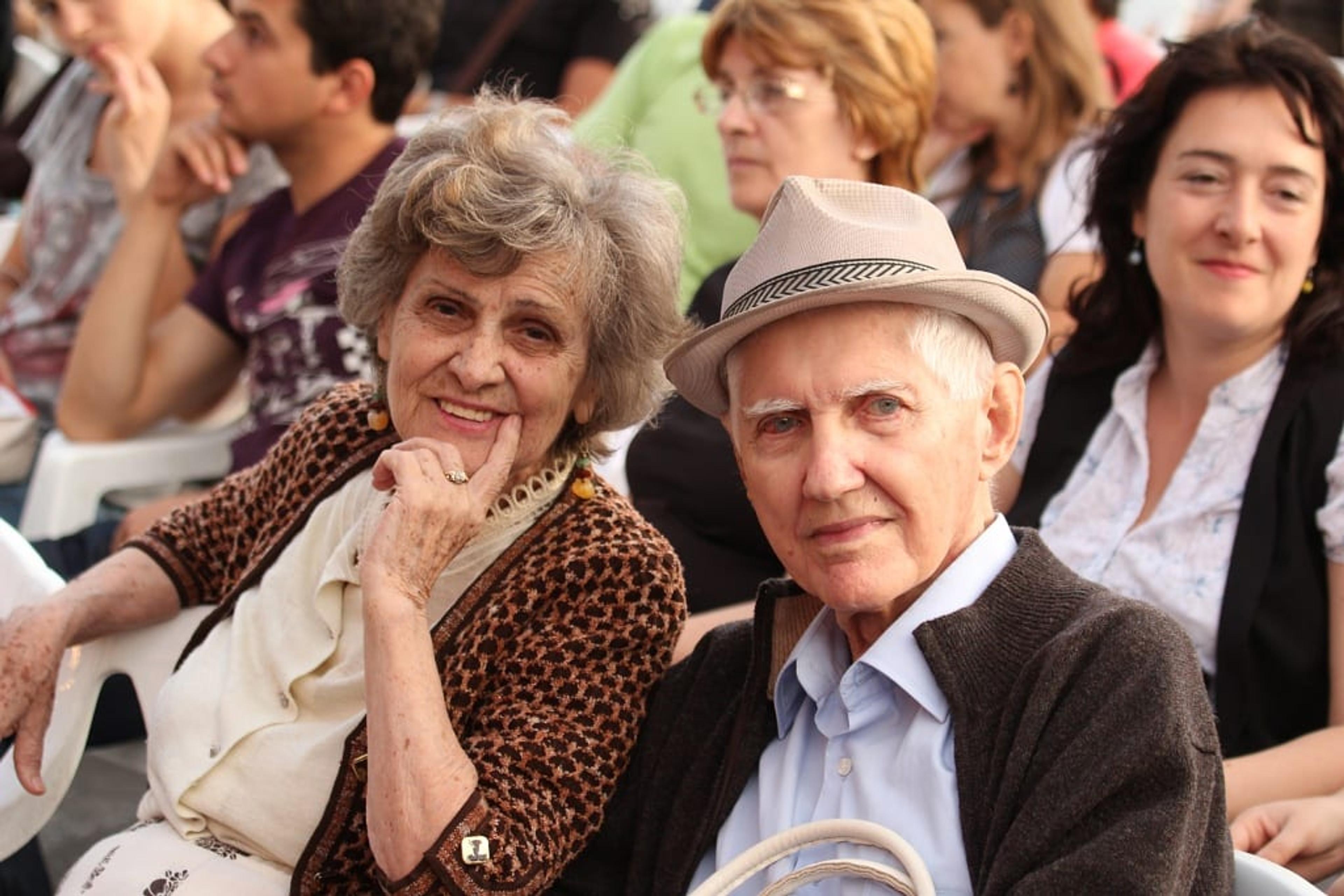 An older man and woman looking at the camera
