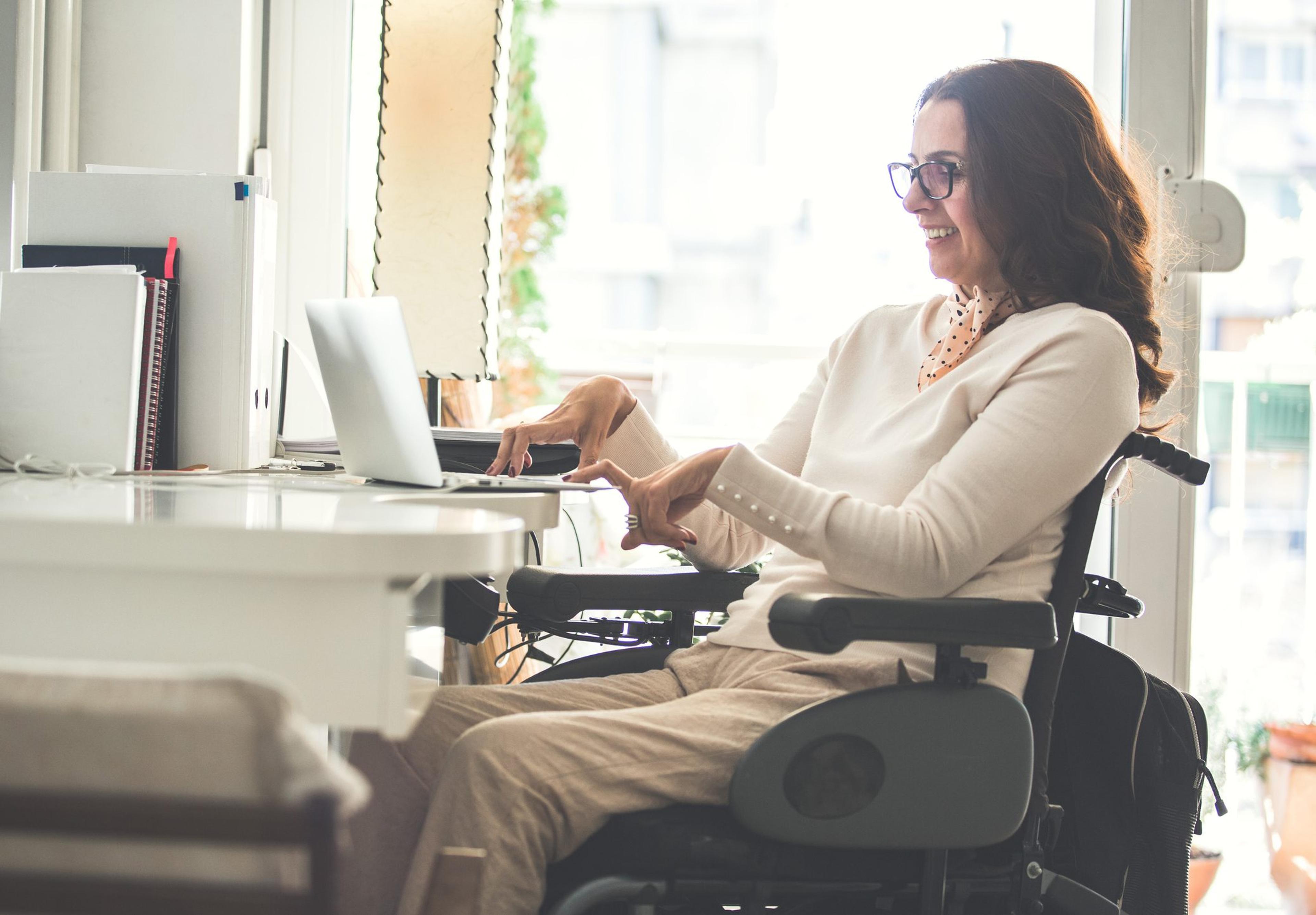 Woman sitting in a wheelchair working