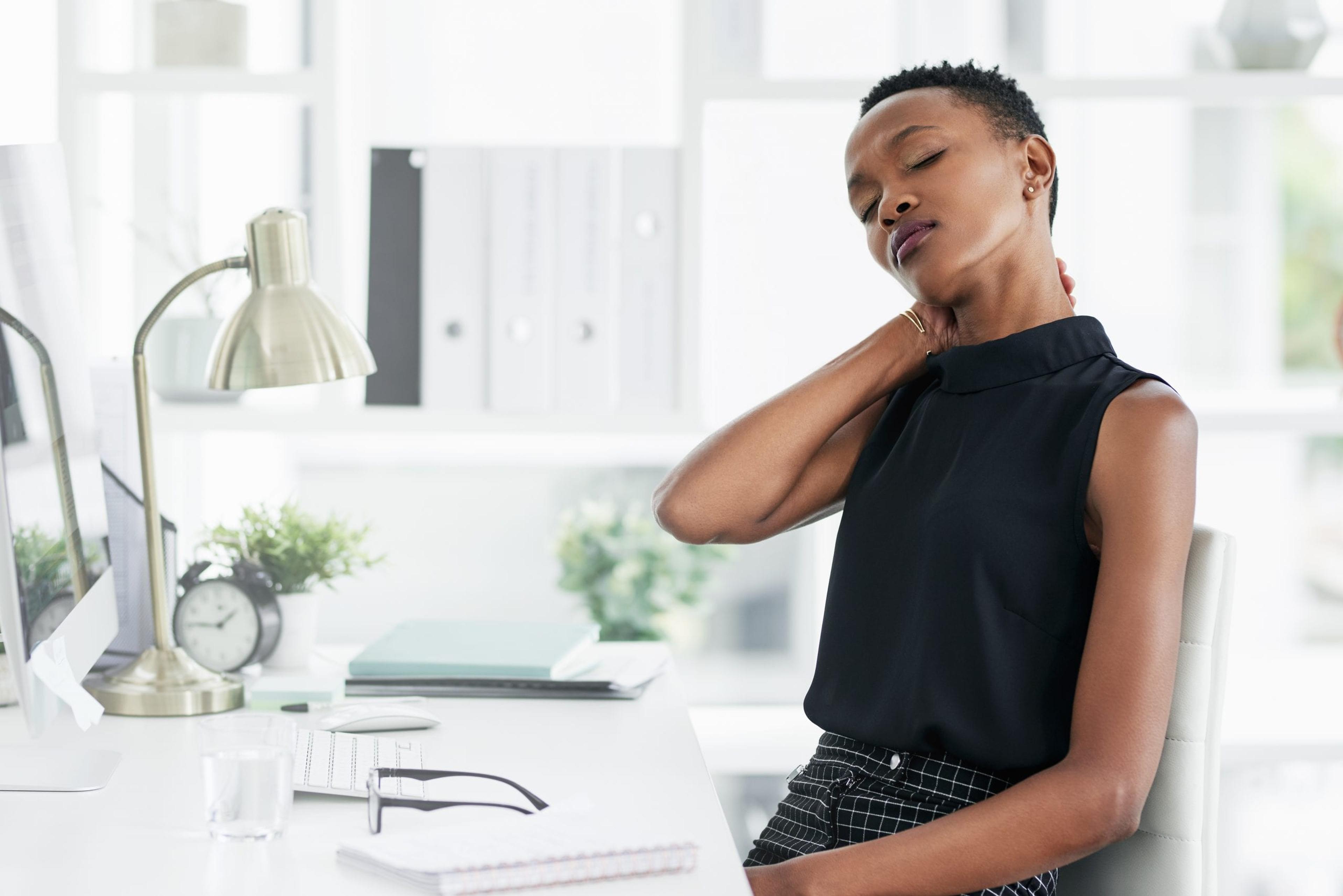 Woman massaging shoulder at work