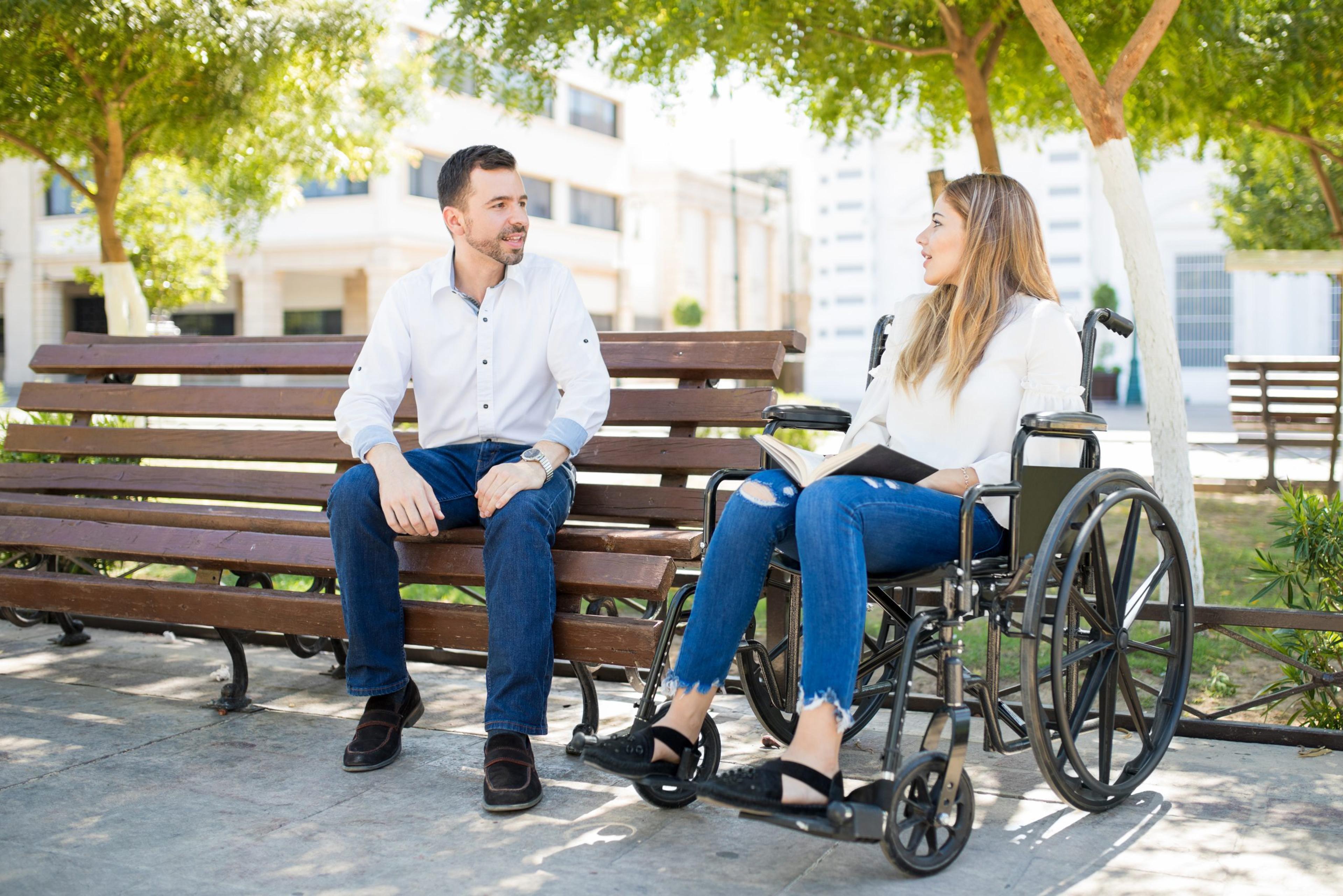 Man talking to woman in wheelchair