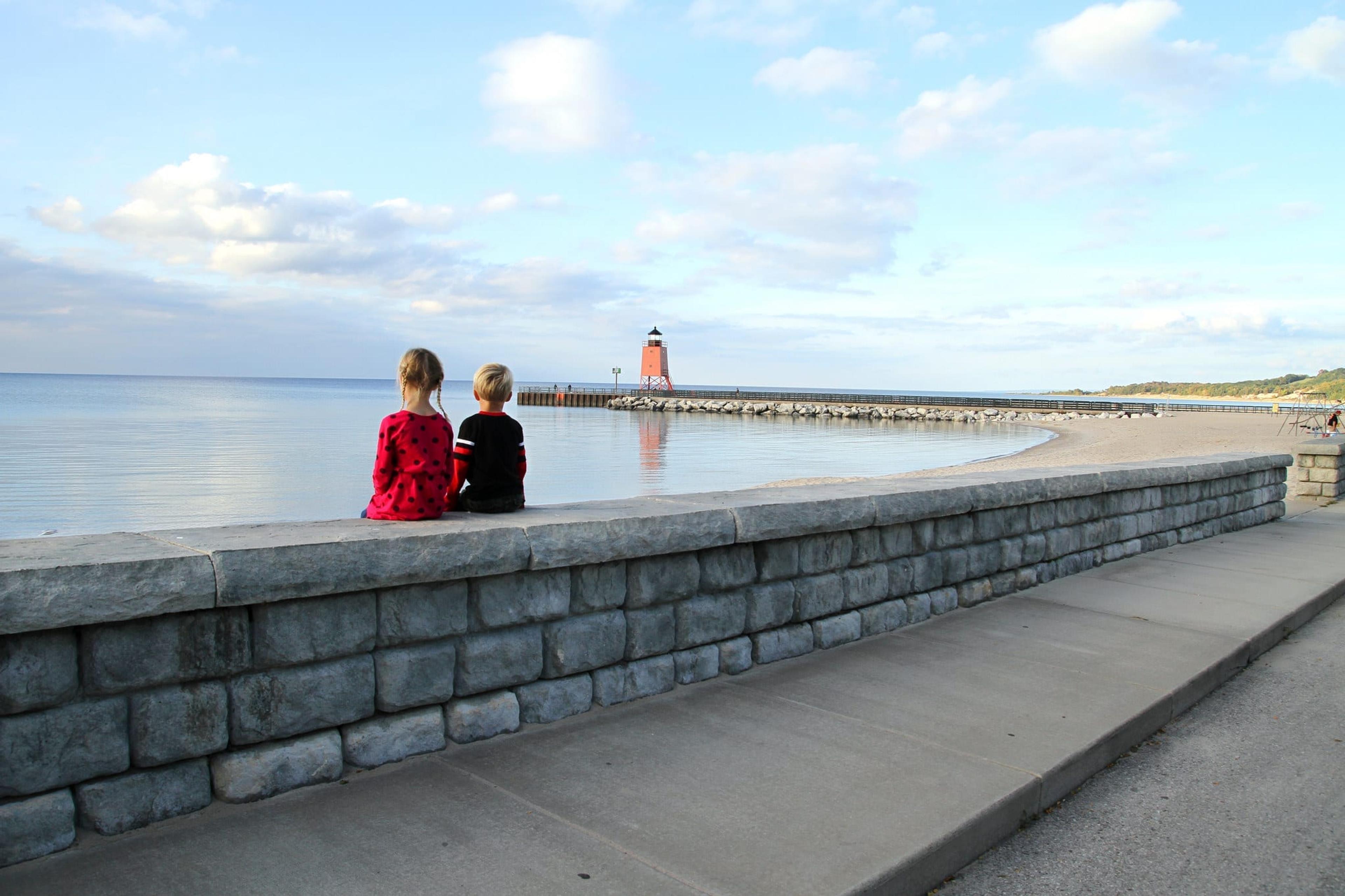 Image of children looking at a lighthouse in the distance in Charlevoix, MI.