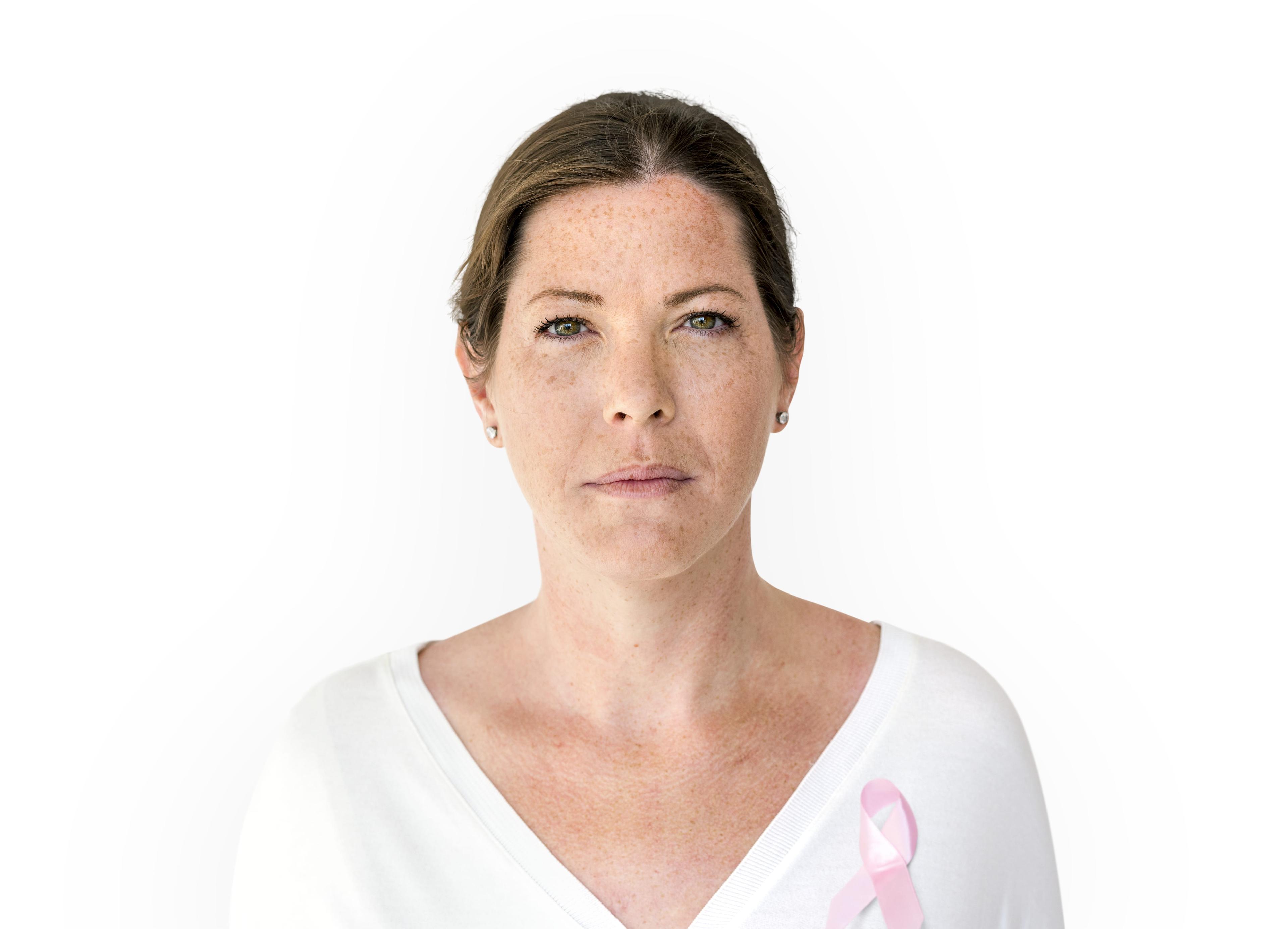 Woman with pink ribbon for breast cancer awareness charity studio portrait