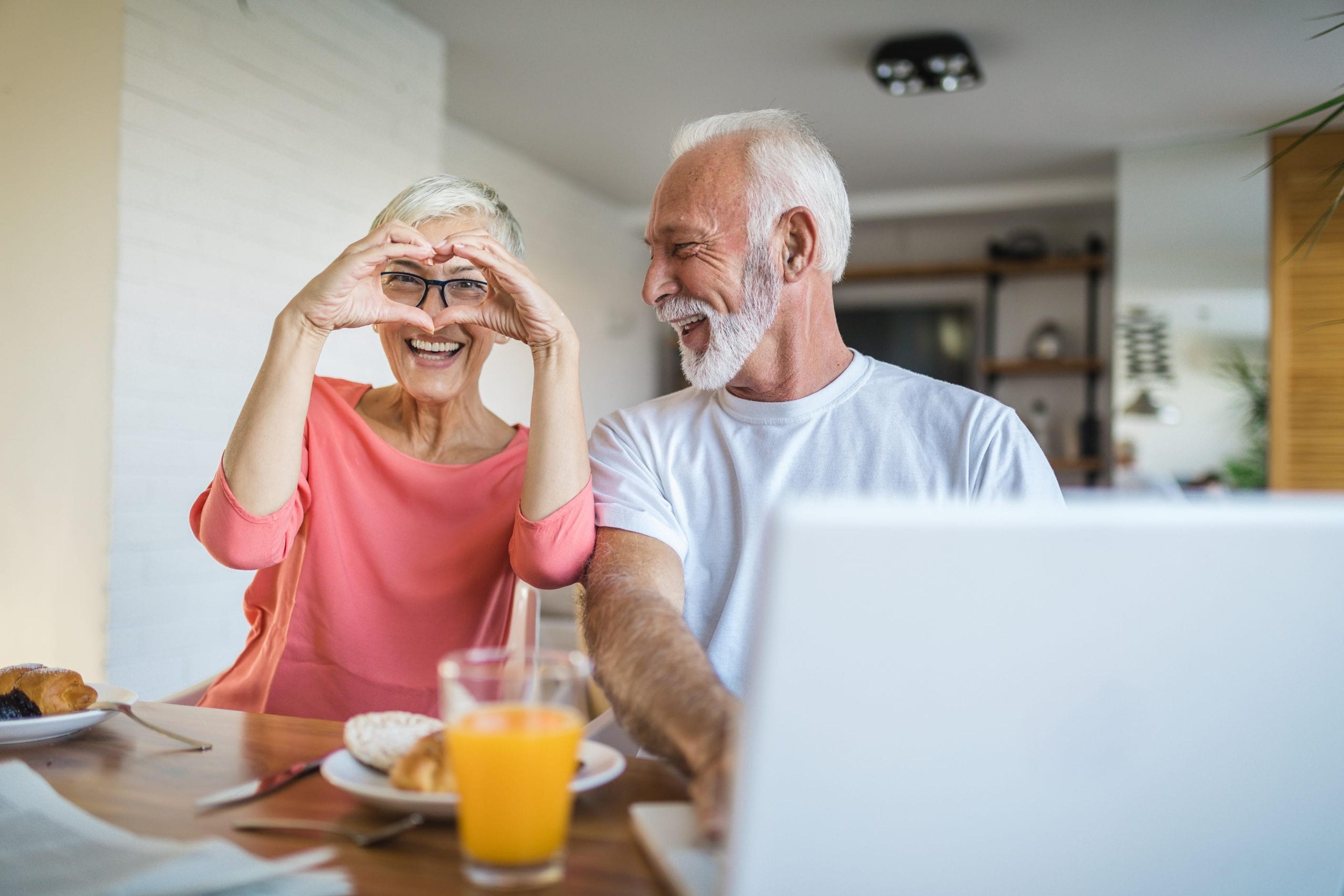 Cute and lovely senior adult couple, spending their time together in love and tranquility, enjoying a morning breakfast.