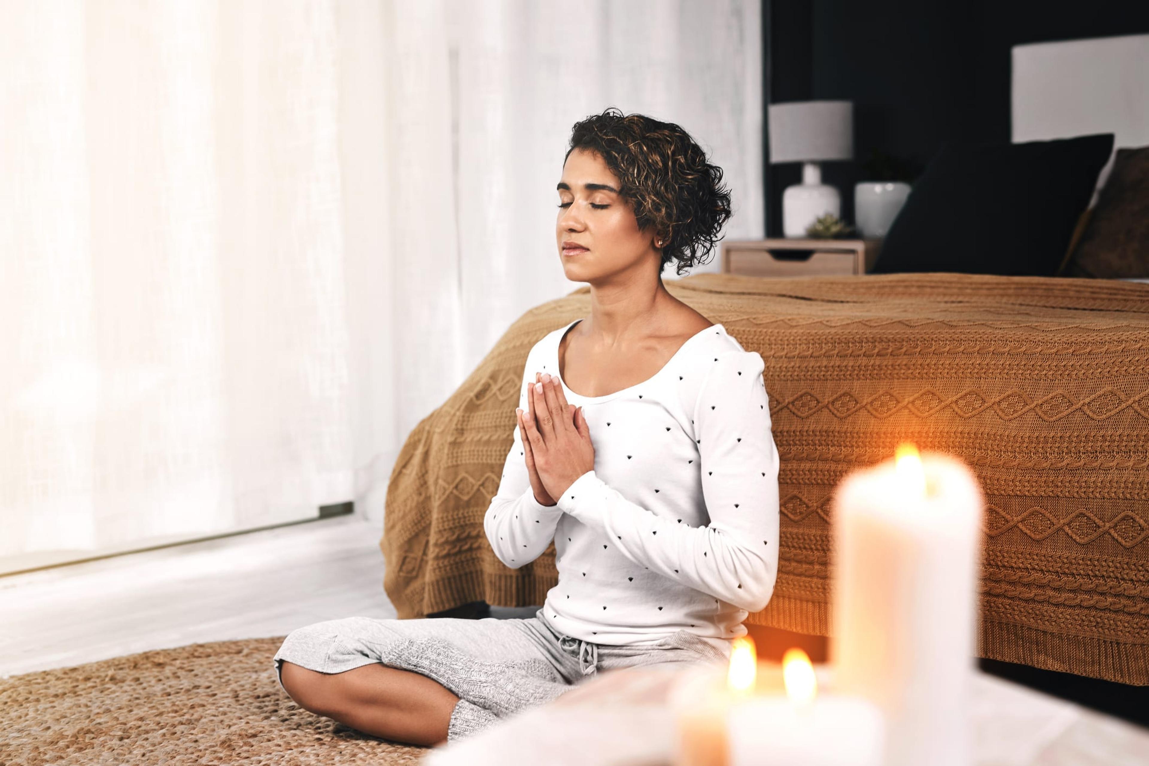 Young woman sitting on the ground practicing a mindful meditation to relieve stress