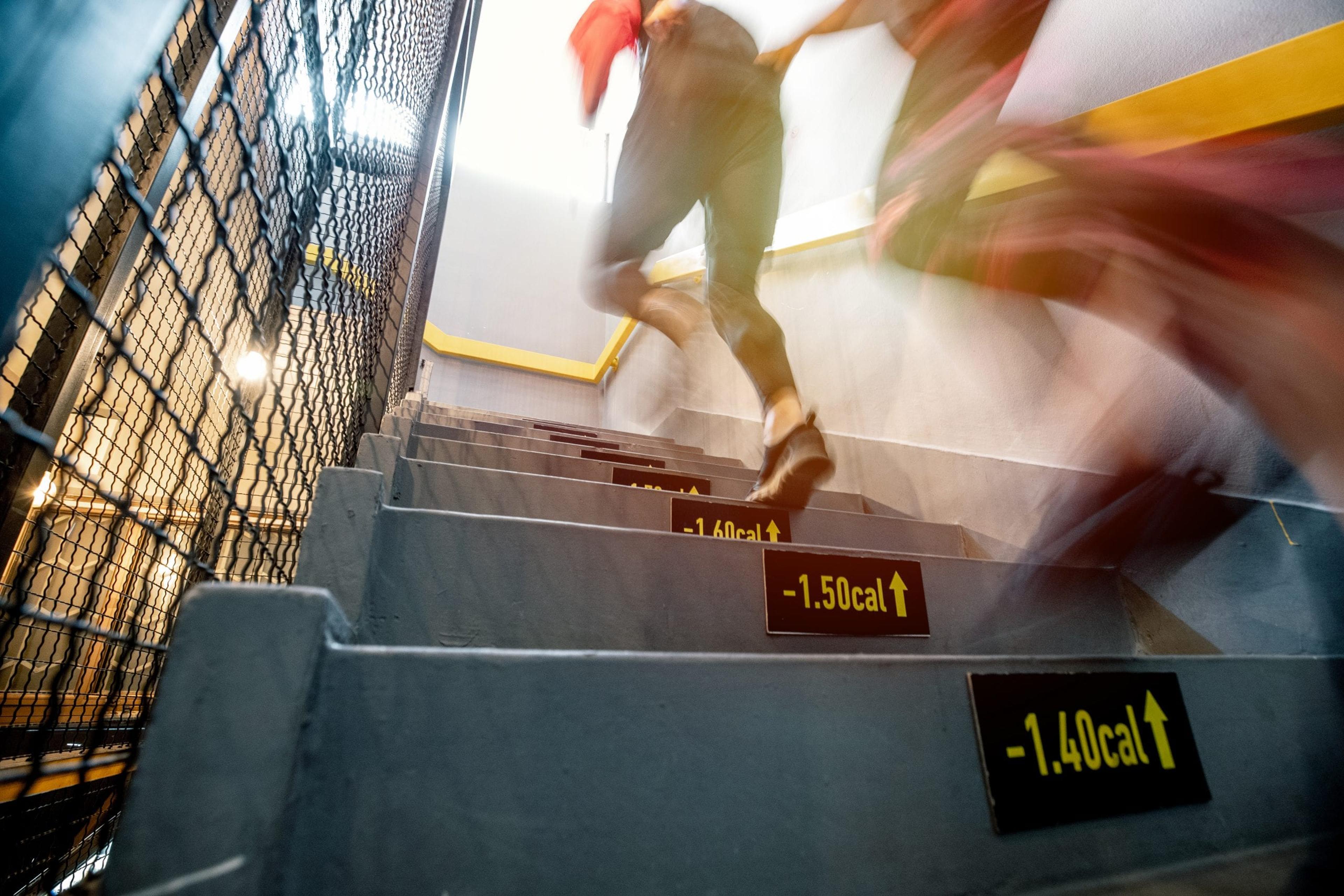 Blurred motion of two people running up stairs