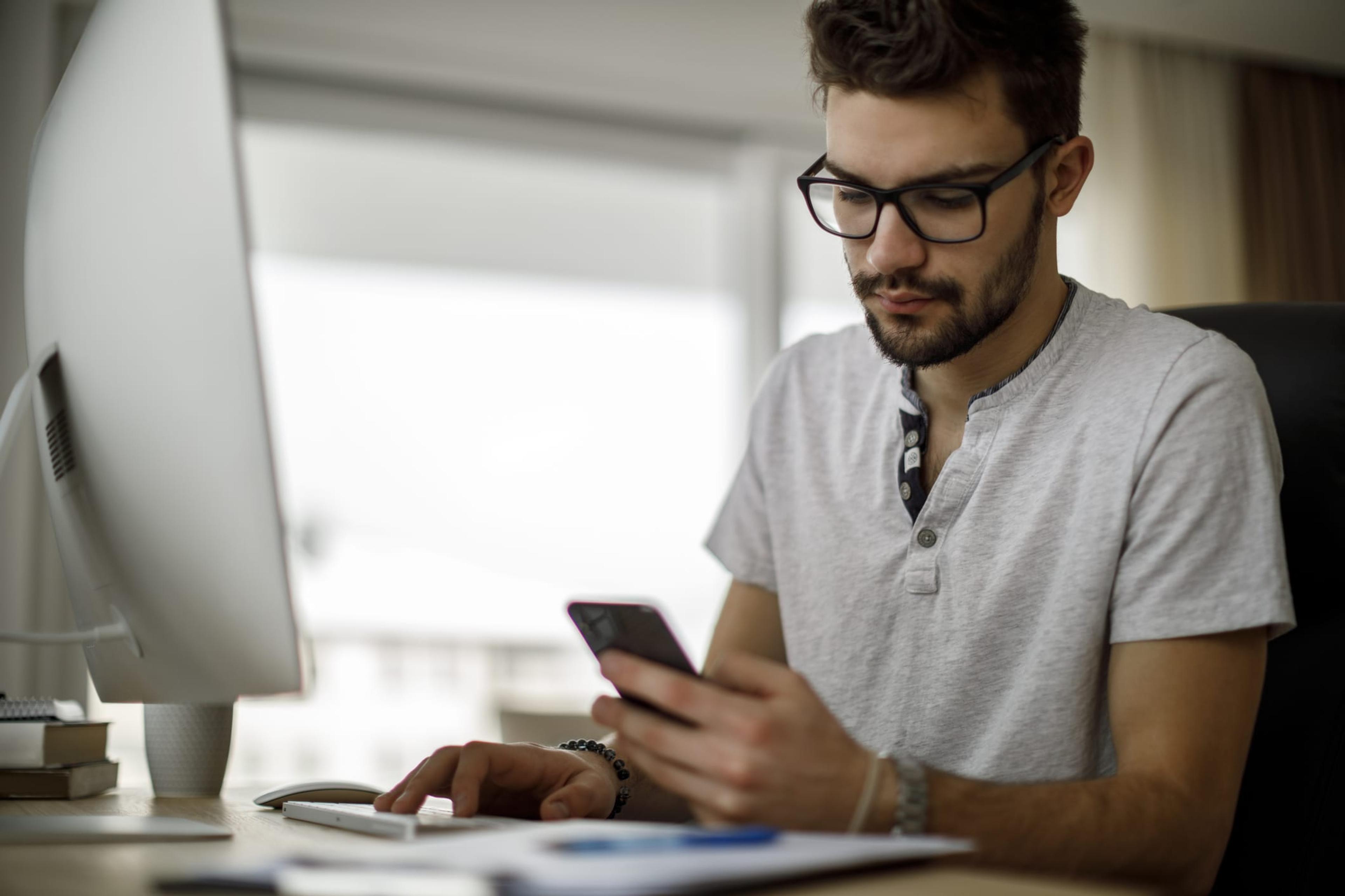 Young man looks at his phone