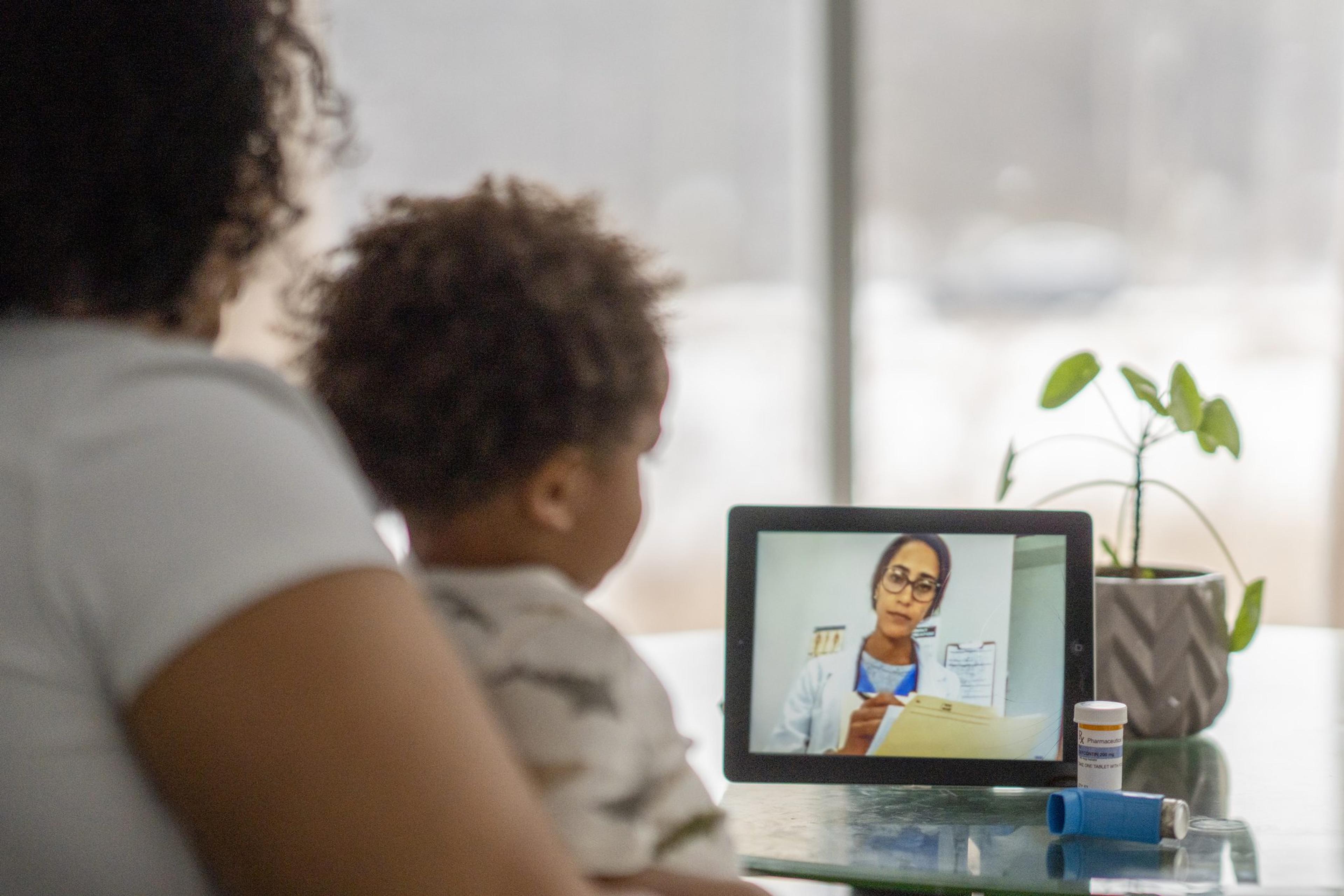 Mom on a remote call with an online doctor