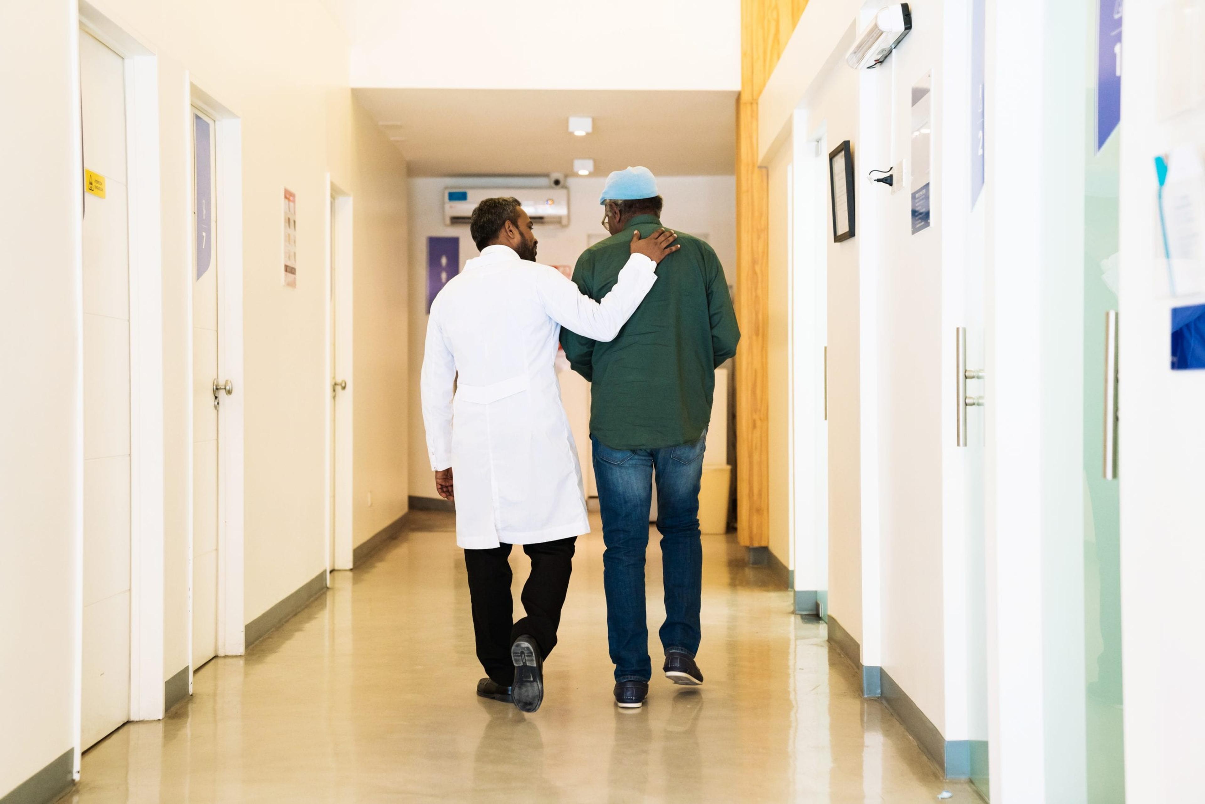 Doctor talking with a male patient in a hallway