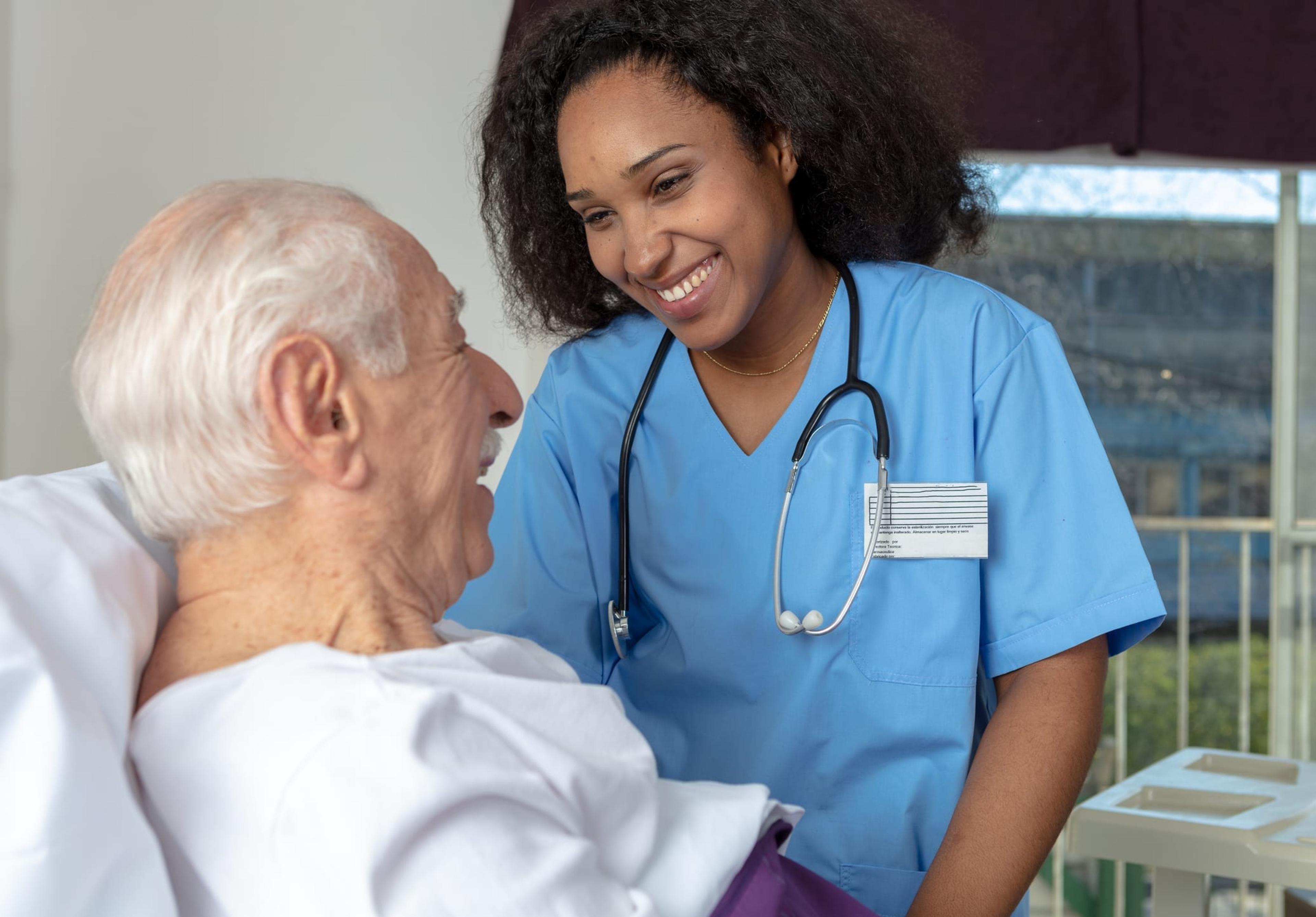 Nurse smiling at a patient lying in bed