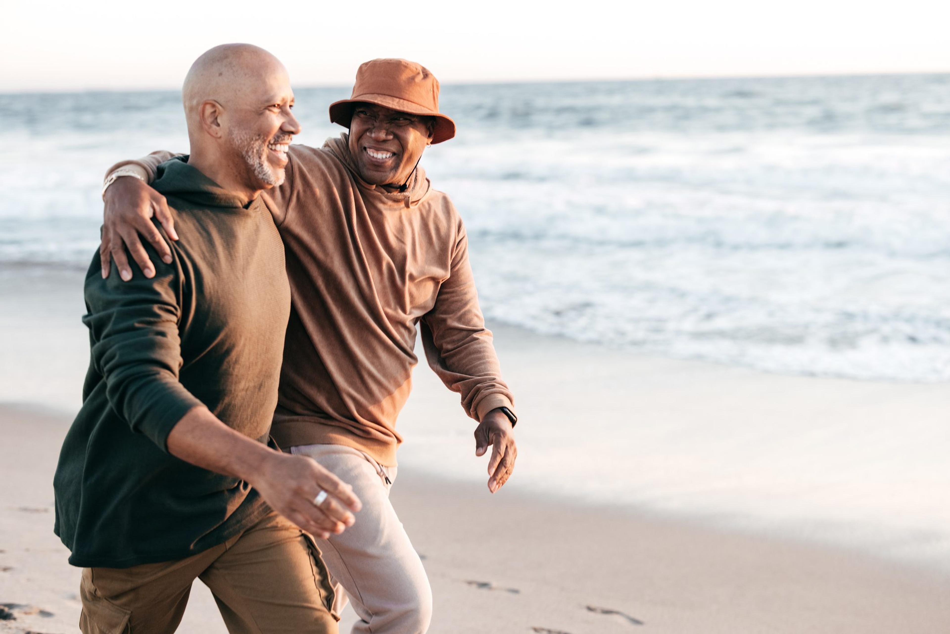 Gay senior couple walking on the beach together