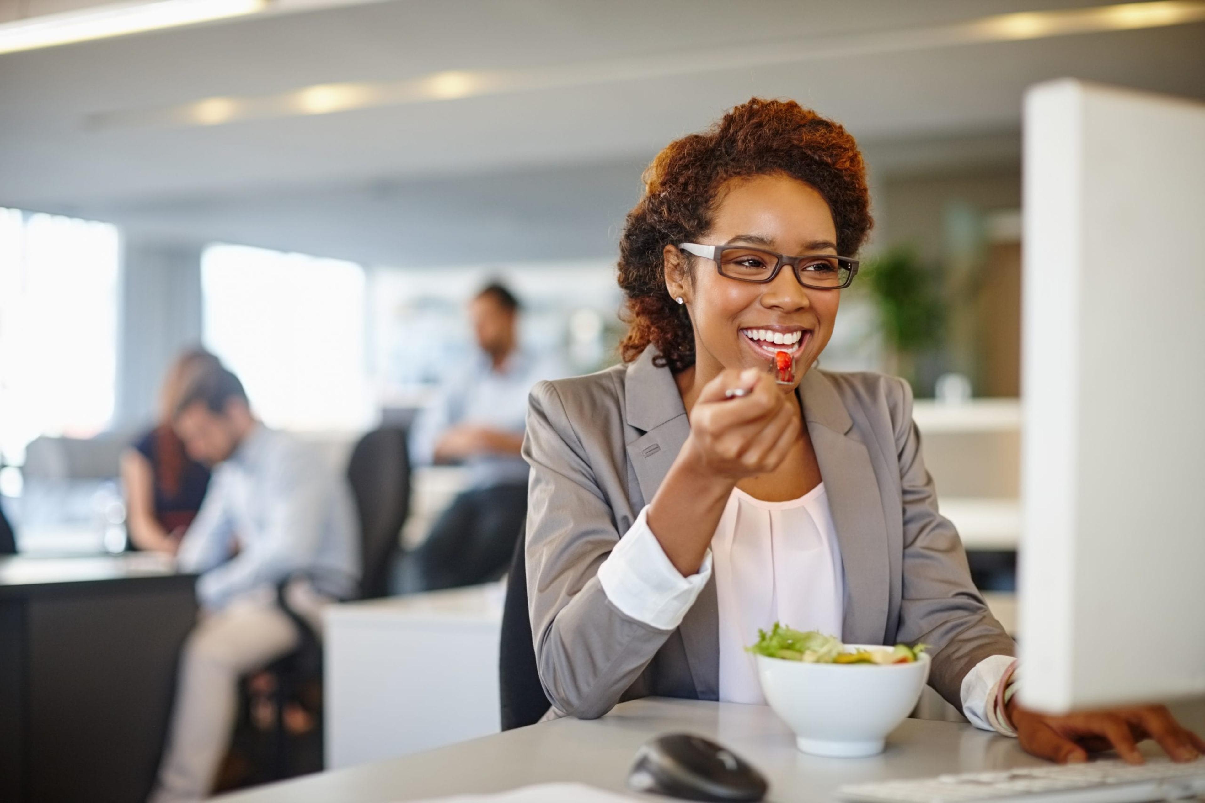 Woman eating a salad at work.