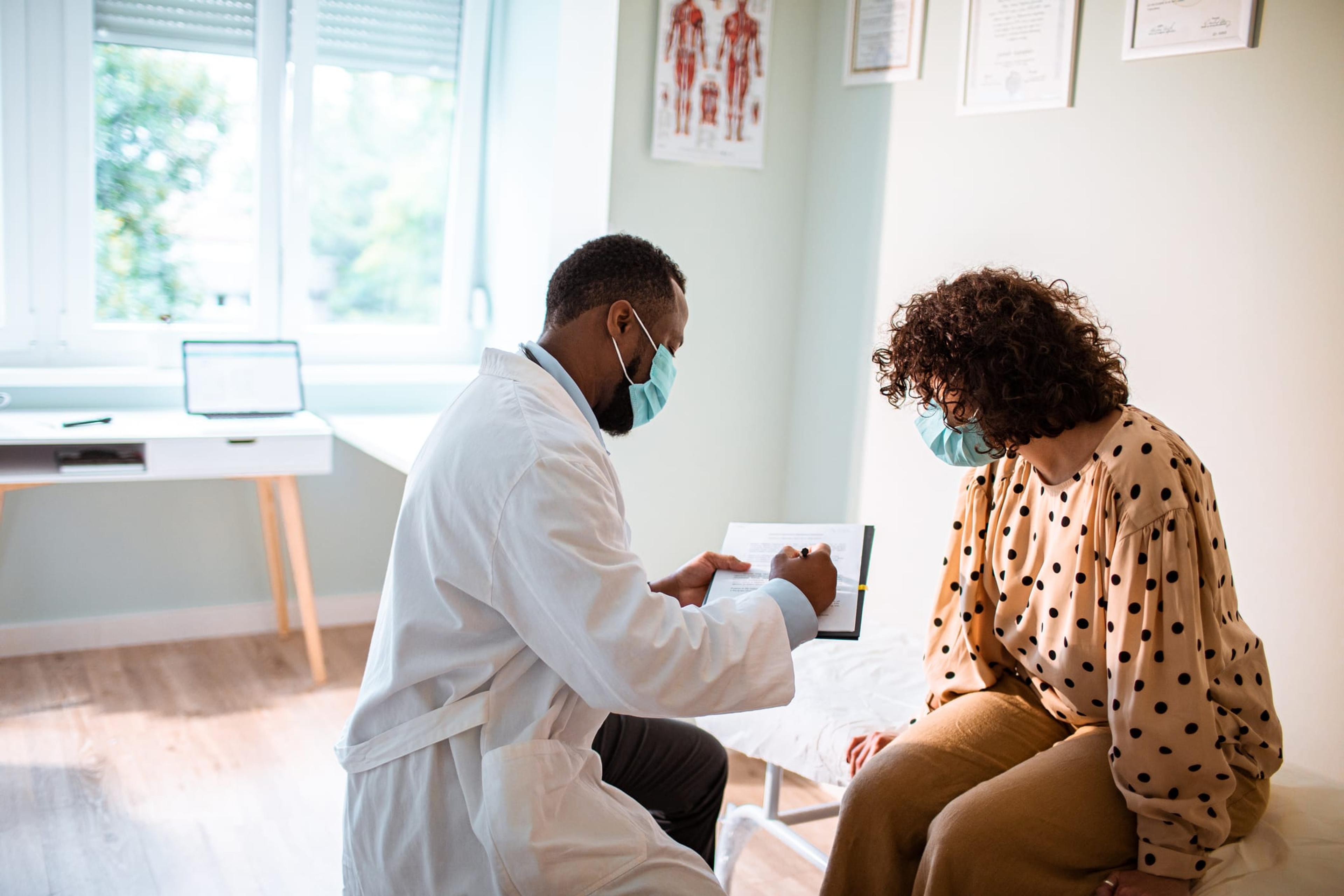 Doctor explains results to young woman screening for colorectal cancer