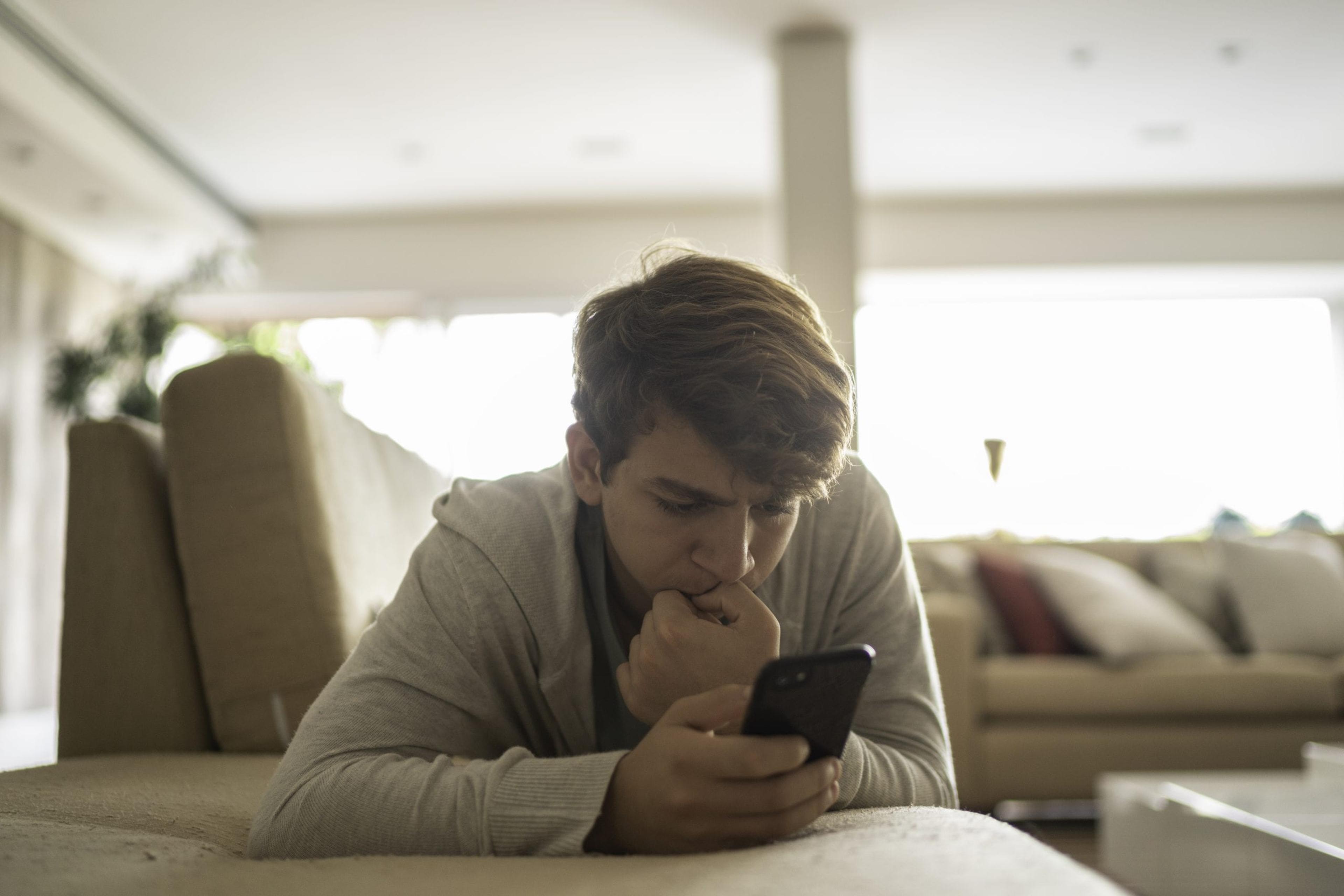 Teen looking at his phone with concern