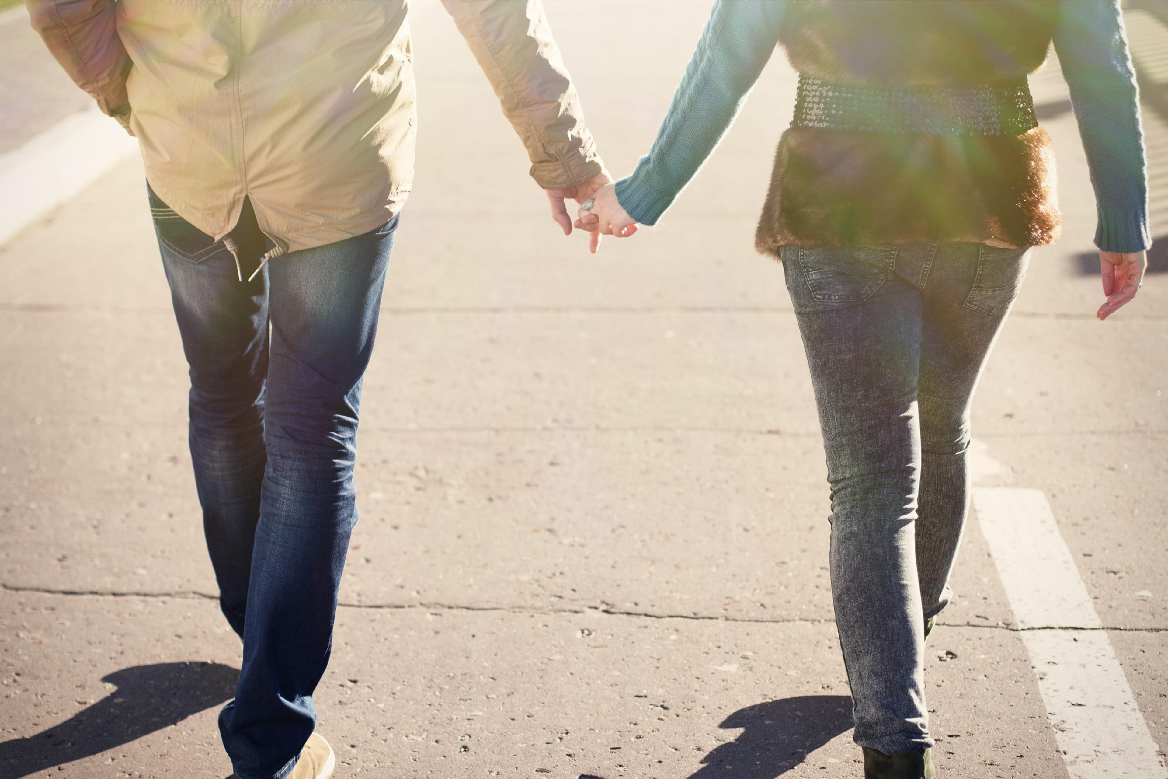 Young couple in an autumn city goes hand in hand