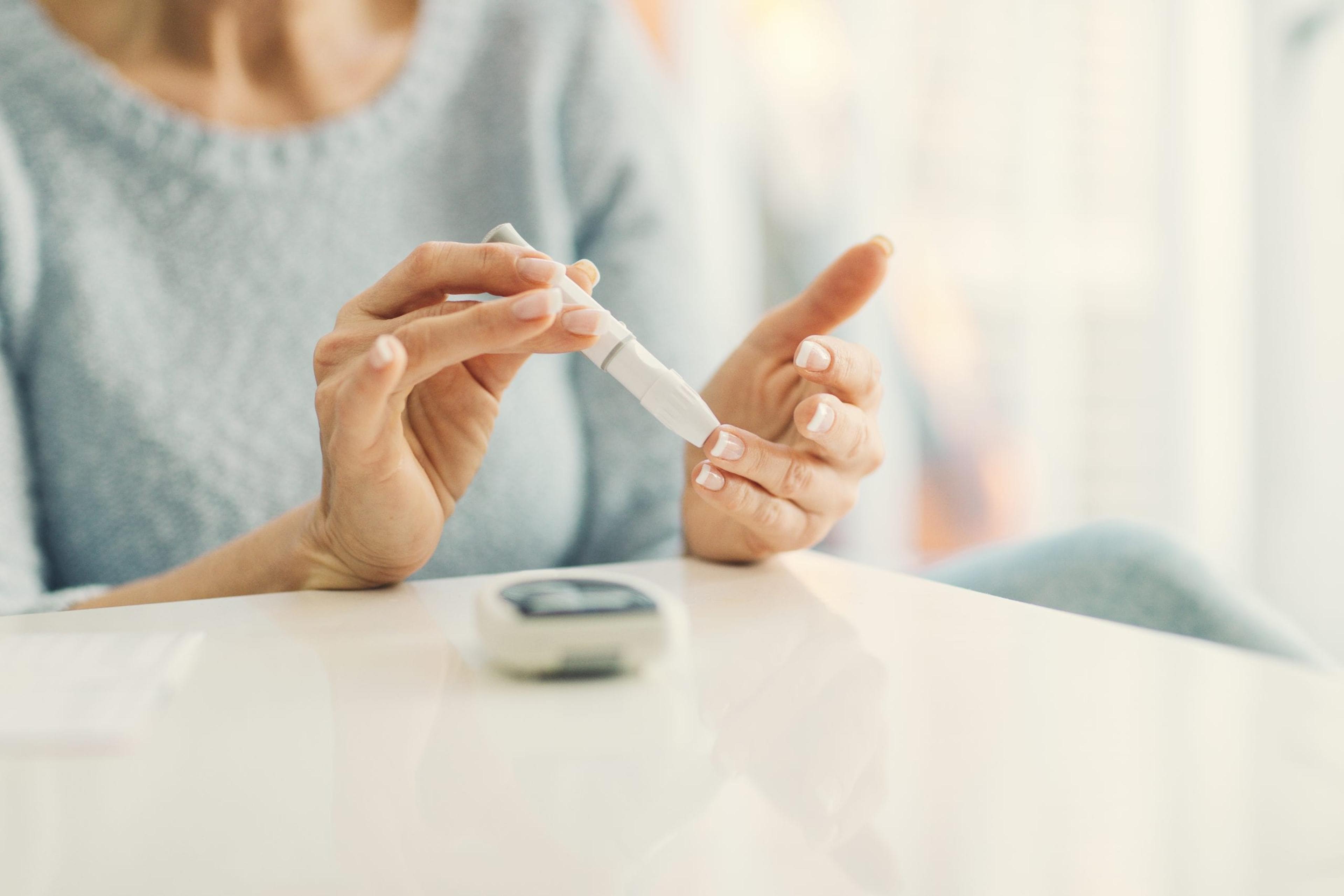 Woman checking her blood glucose monitor