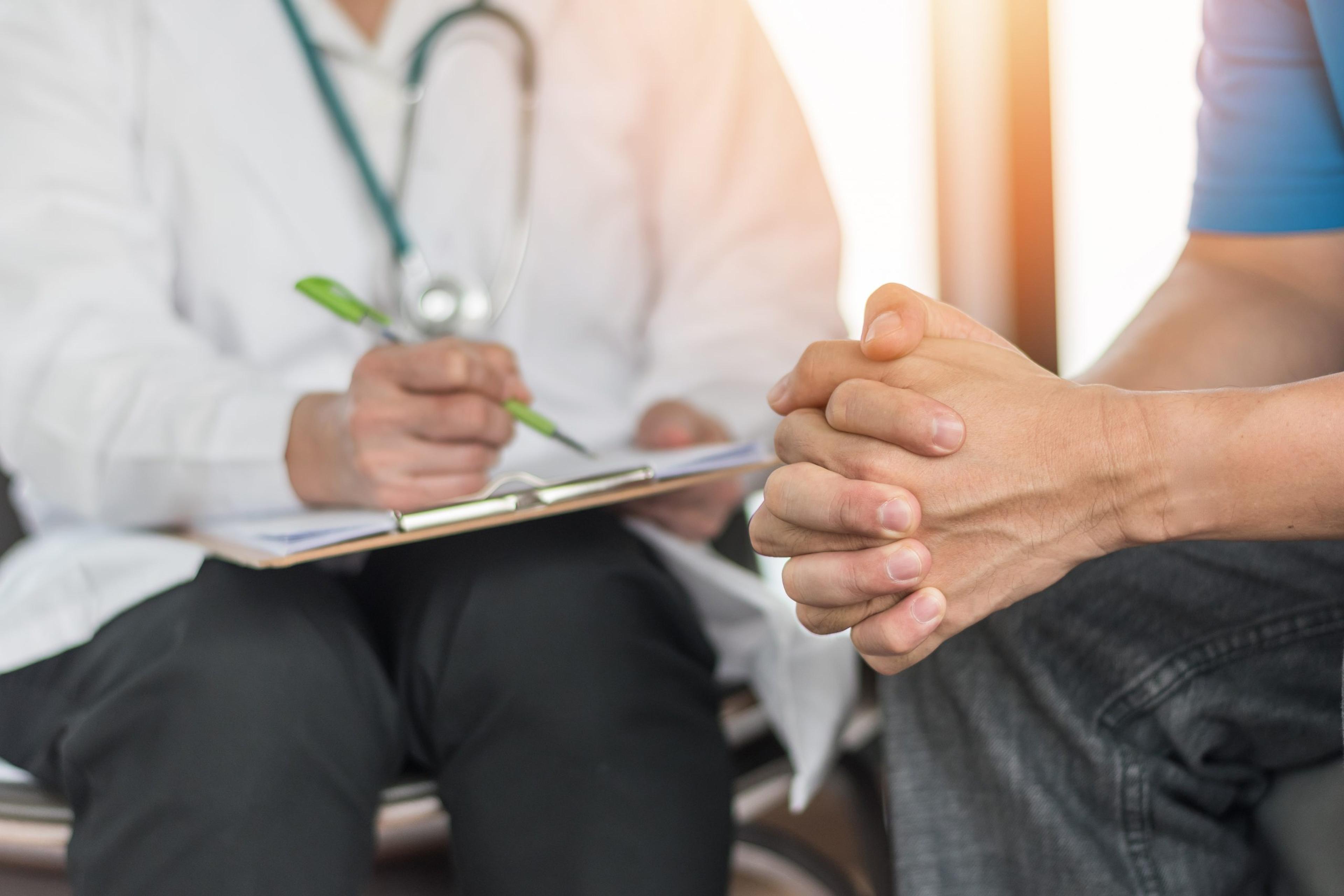 Close up image of doctor meeting with patient with clasped hands