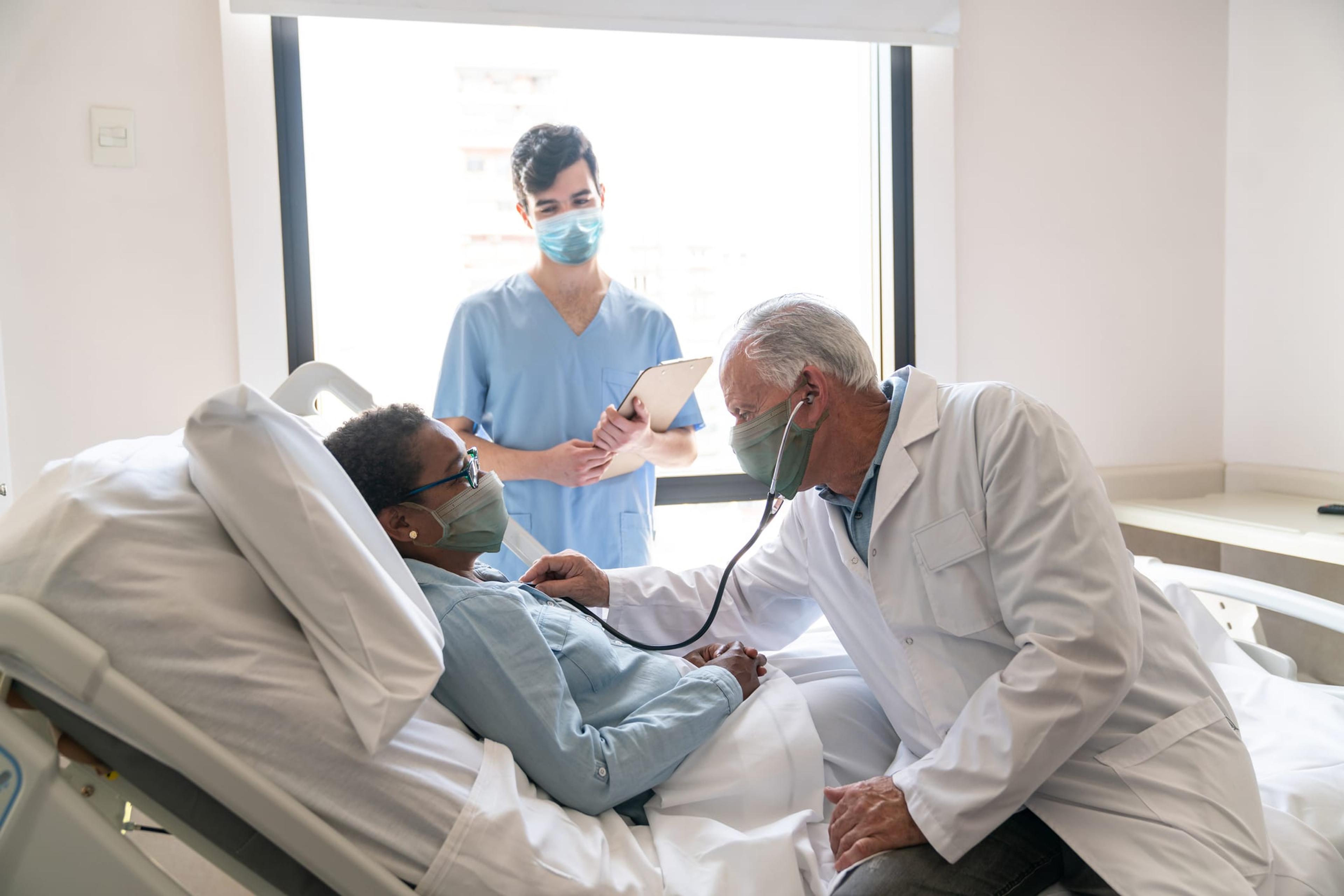 Doctor checks on black female patient in the hospital