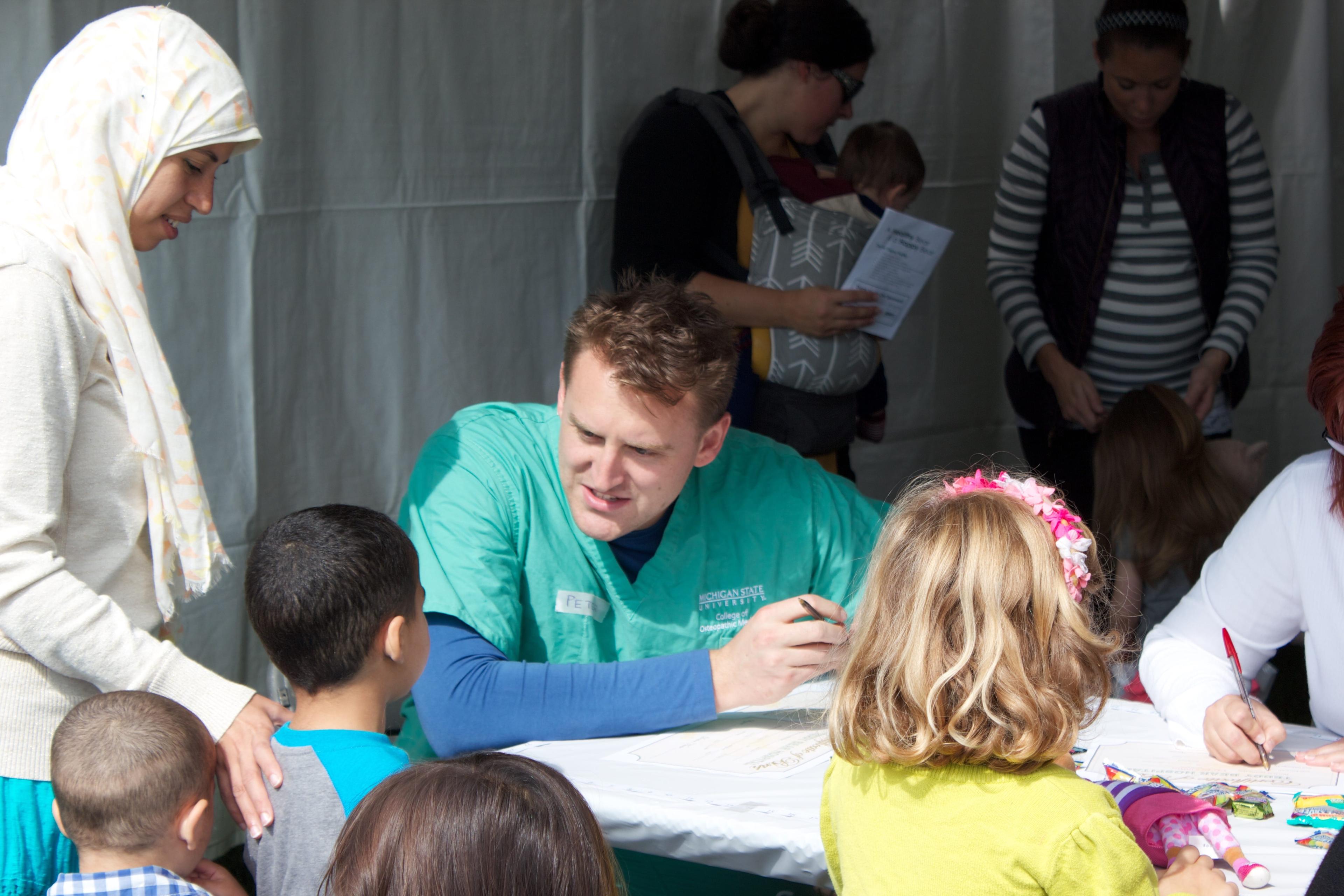 MSU staff talking to children at the Teddy Bear Picnic.