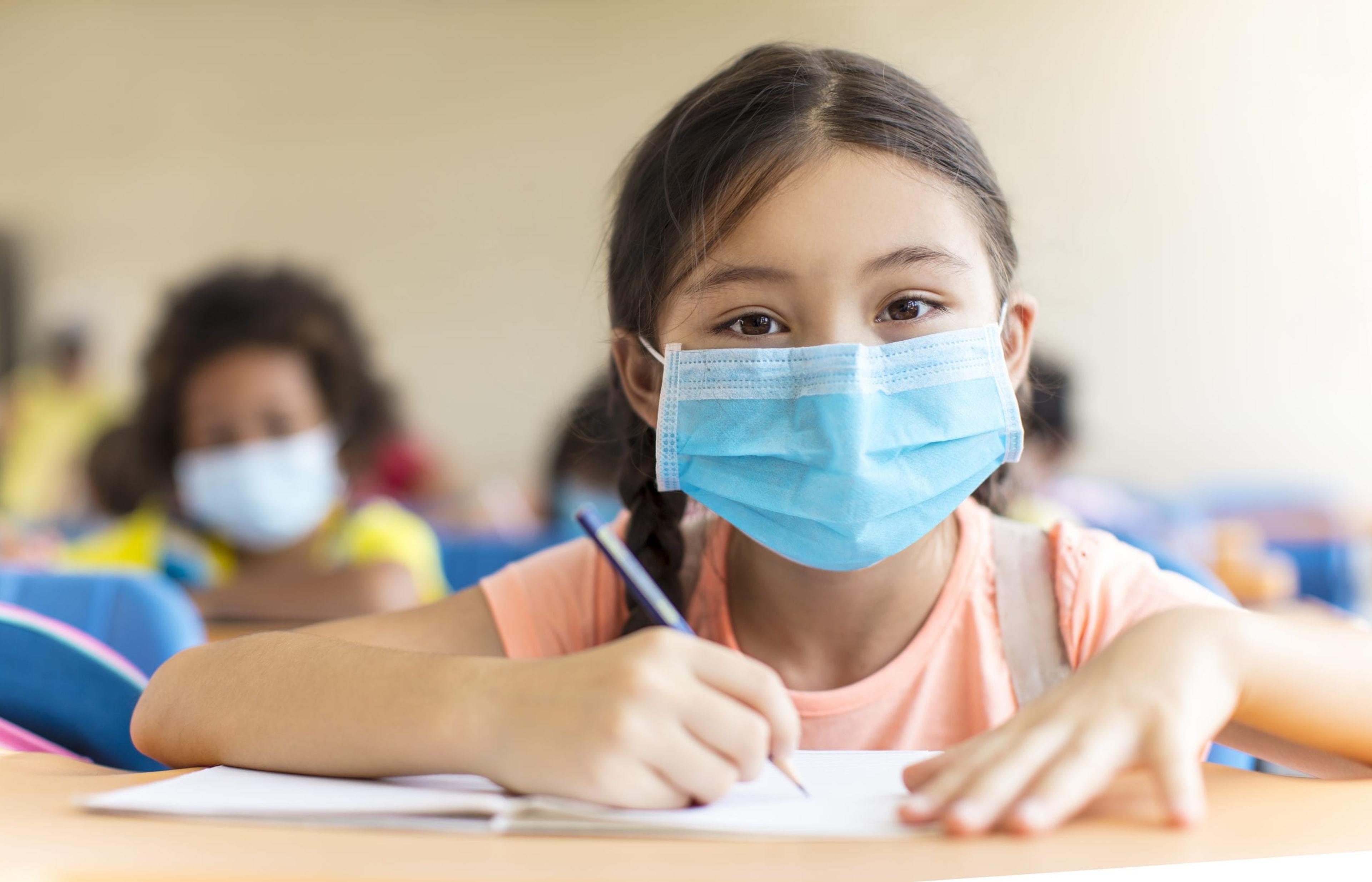 Young girl wearing a mask at school