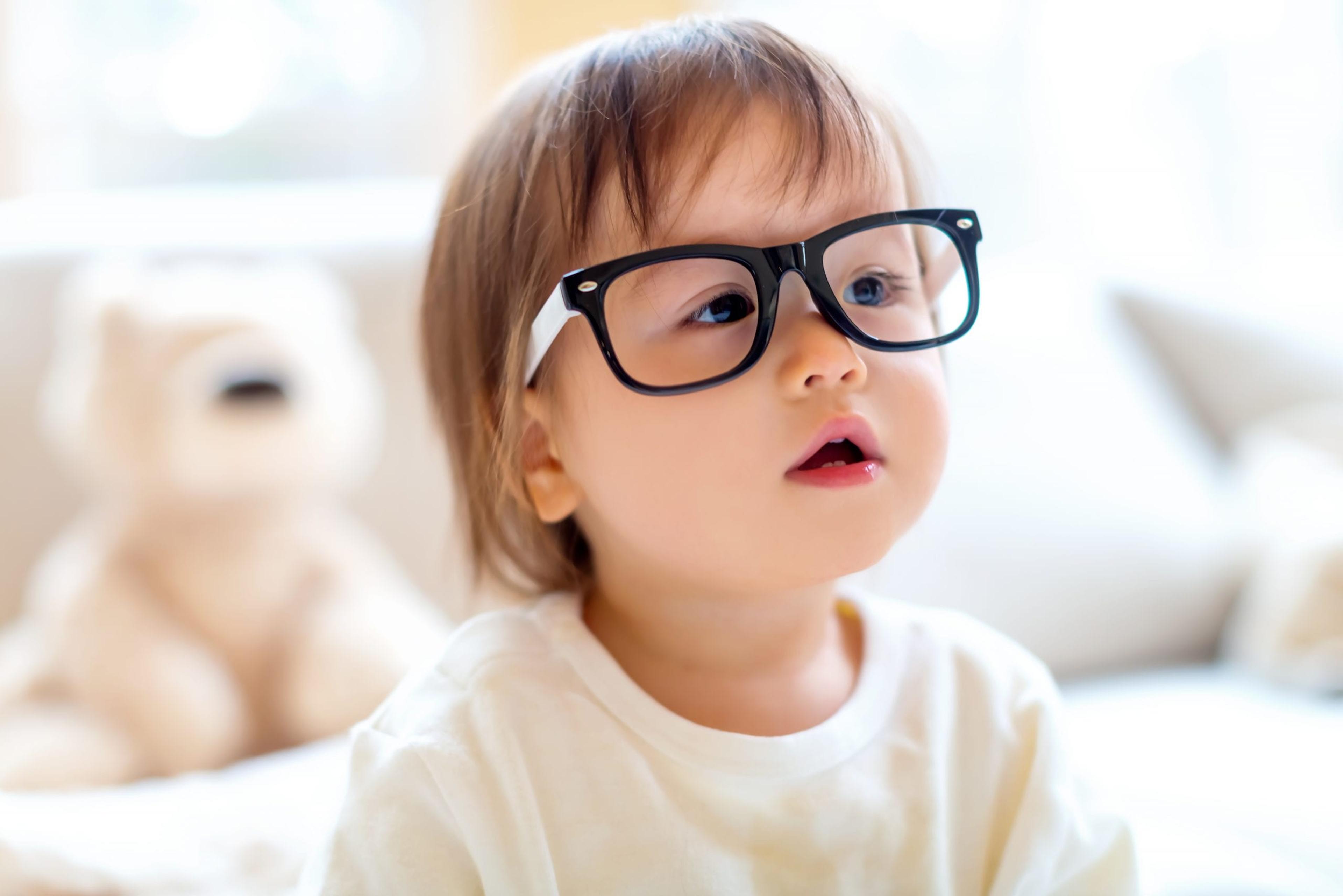 Little girl wearing glasses that are too big for her