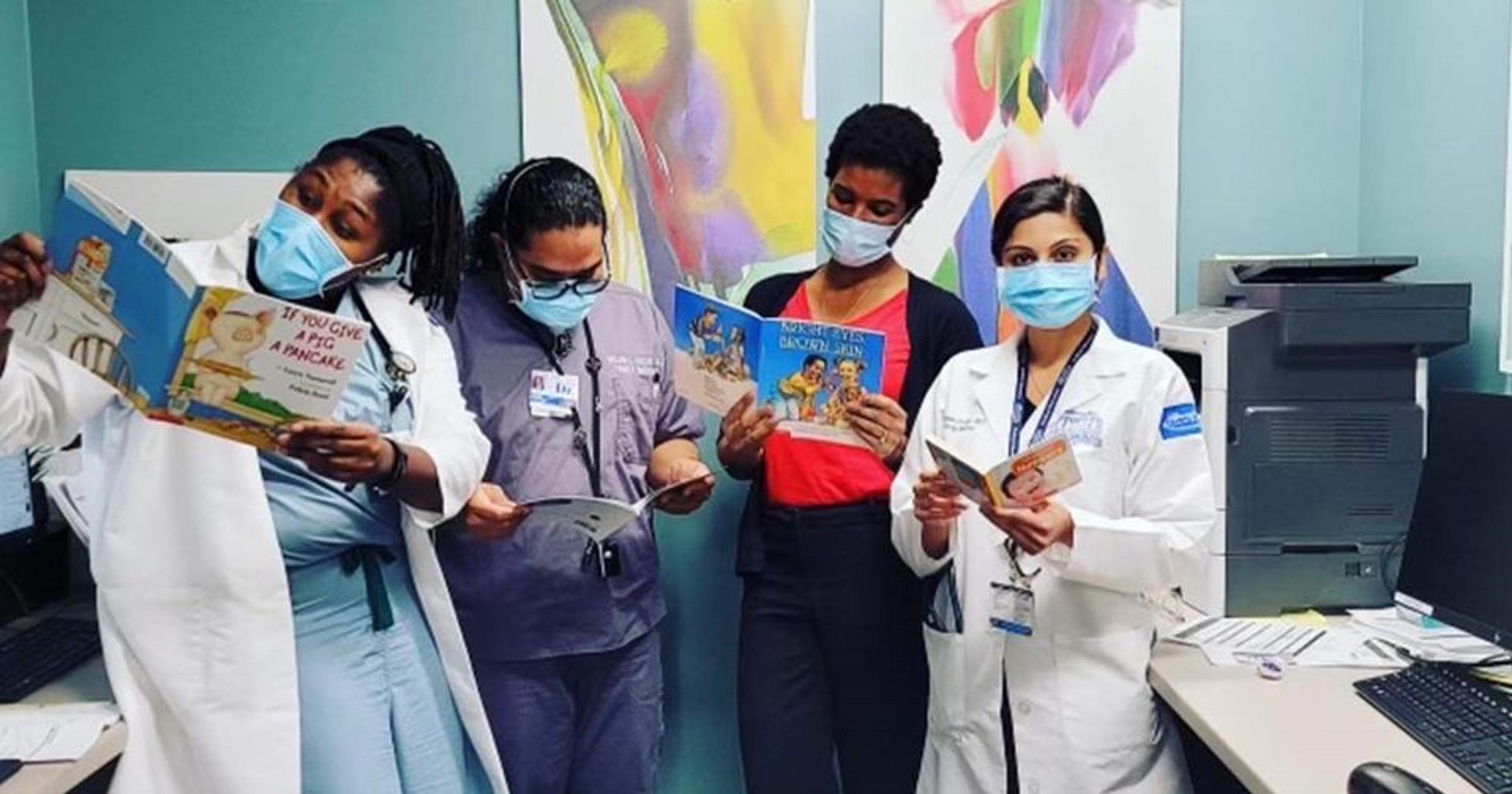 Doctors at Henry Ford Health pose for a photo by reading children's books.