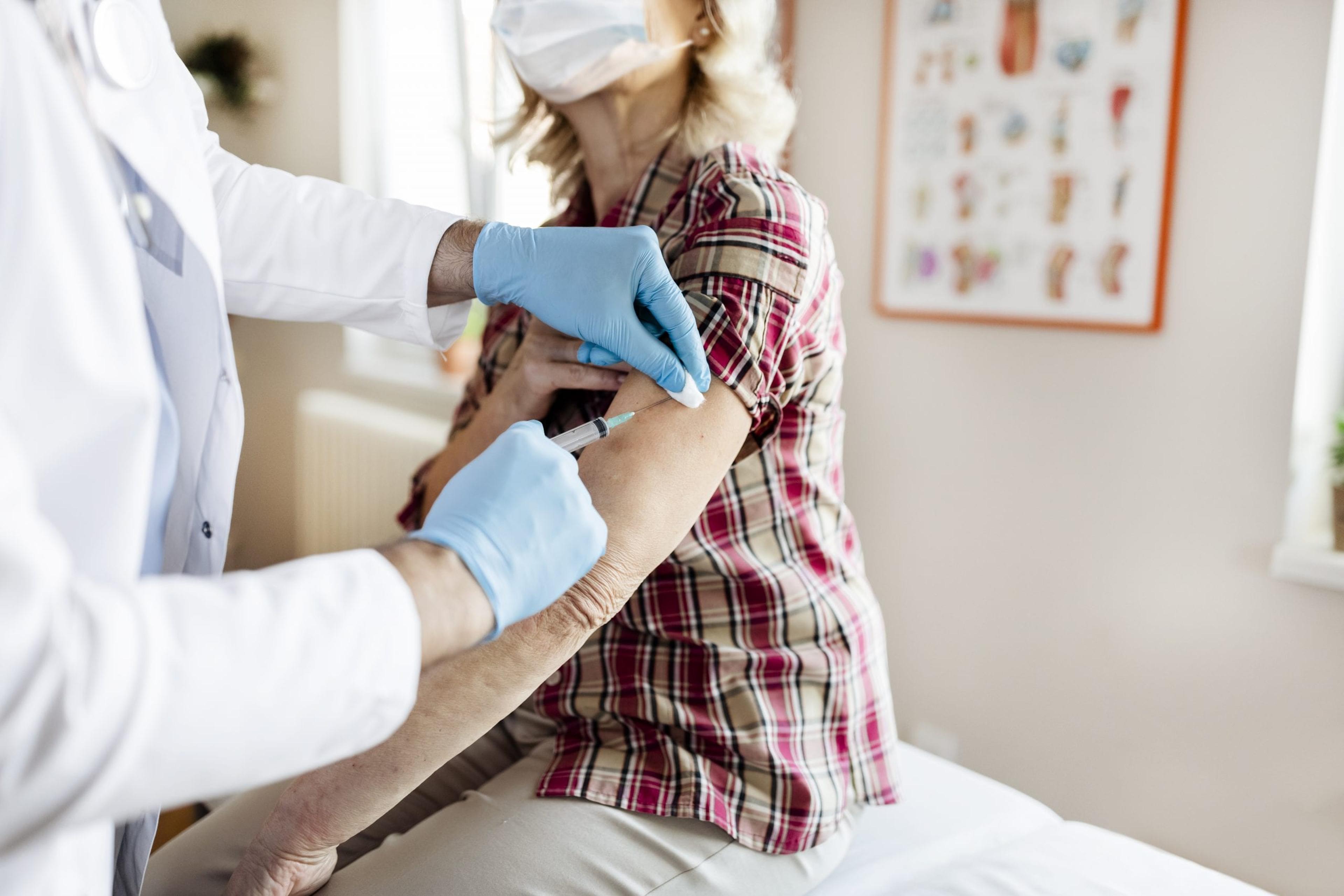 Vaccines for the Elderly. Professional Male Doctor in Blue Sterile Gloves Injecting Vaccine to Senior Woman. Vaccination, Medicine and Healthcare. Covid, Coronavirus Vaccine