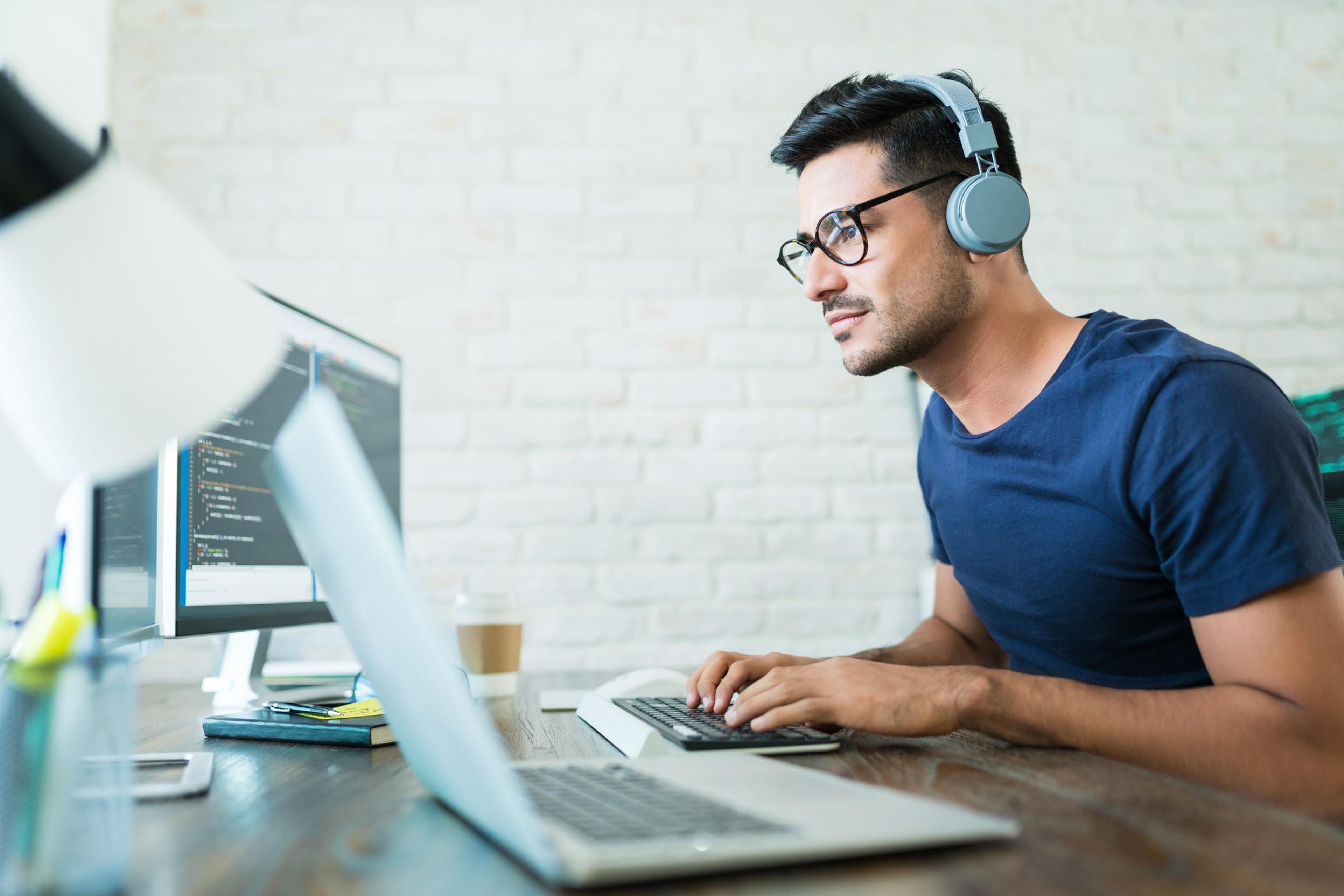 Man wearing headphones works at a desk