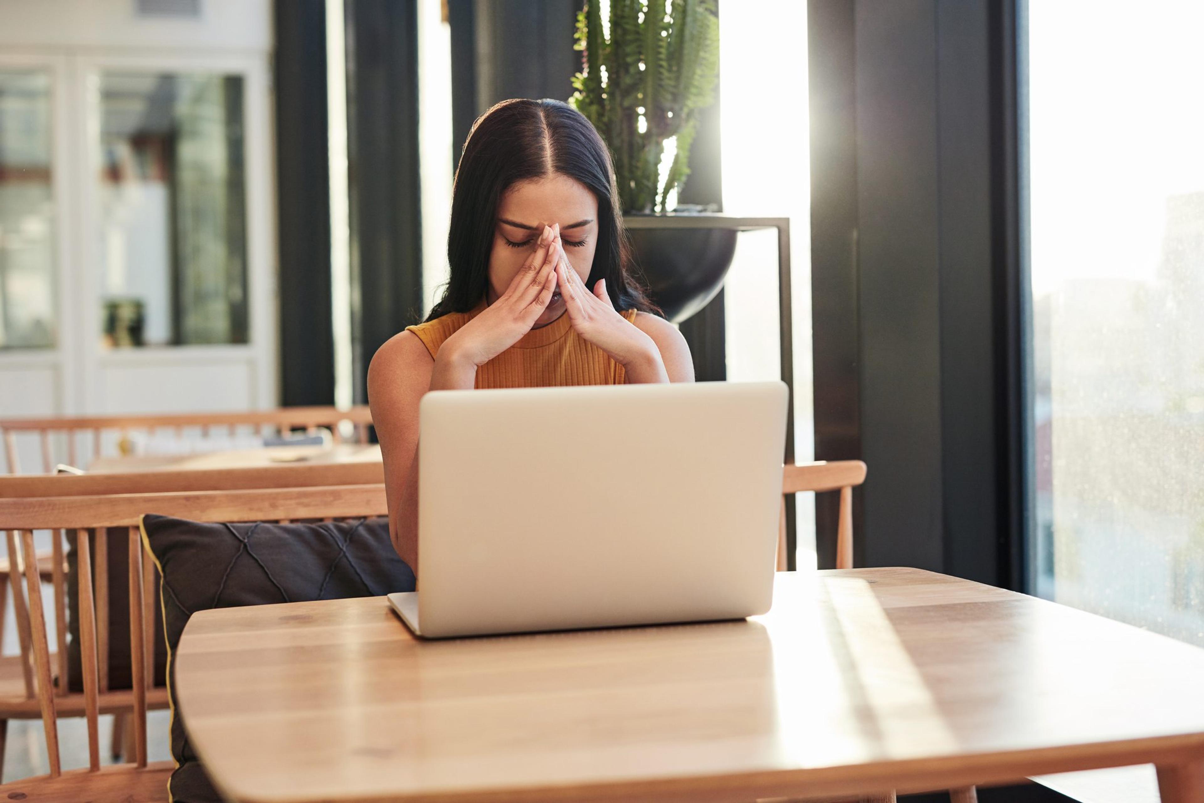 Young woman working at an office with her head in her hands in exasperation