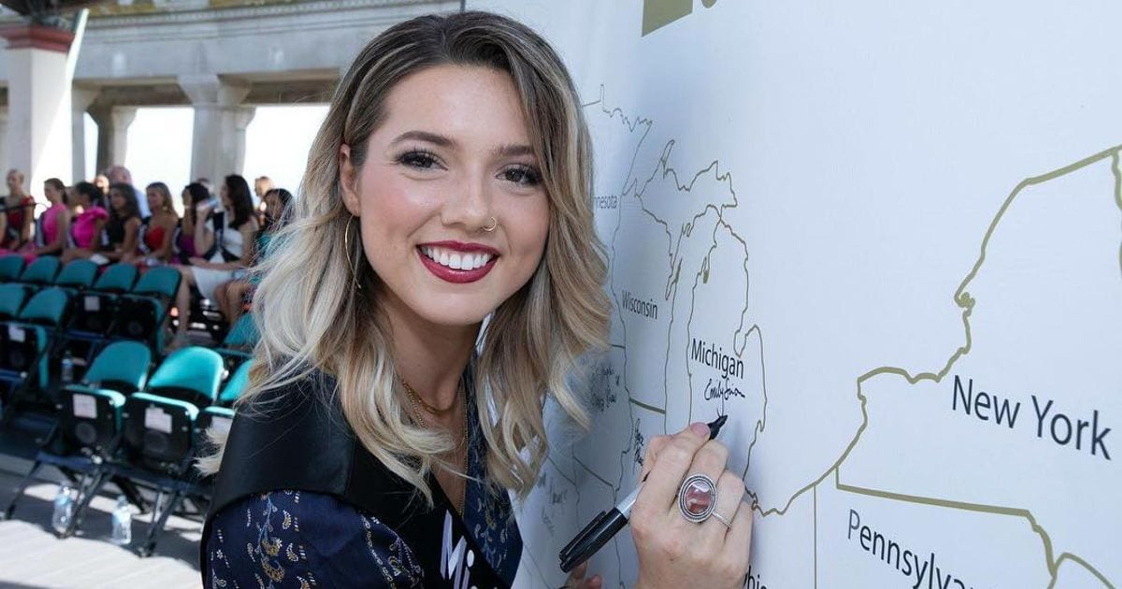 Emily Sioma signing a United States map's Michigan.