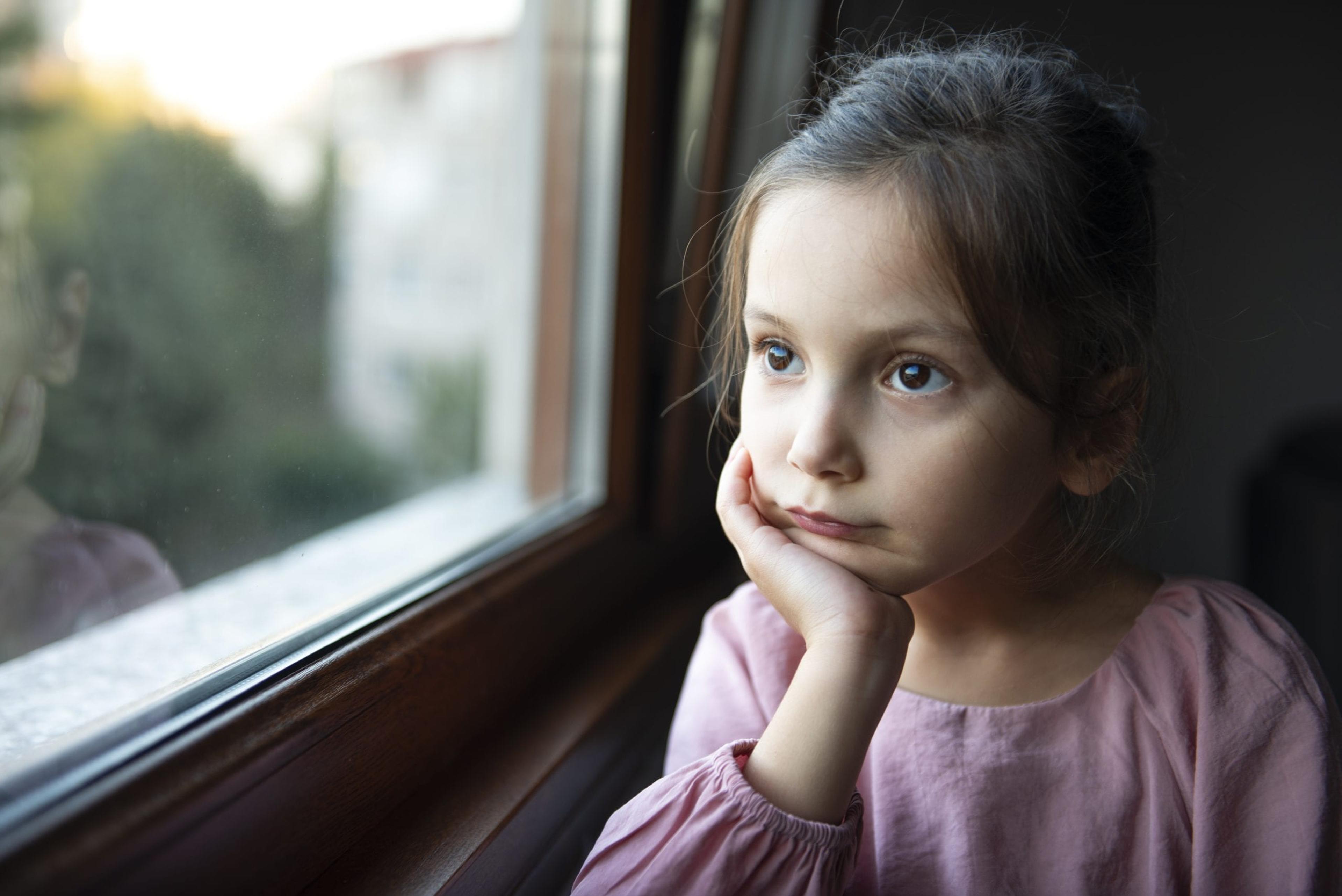 Little girl looking out a window