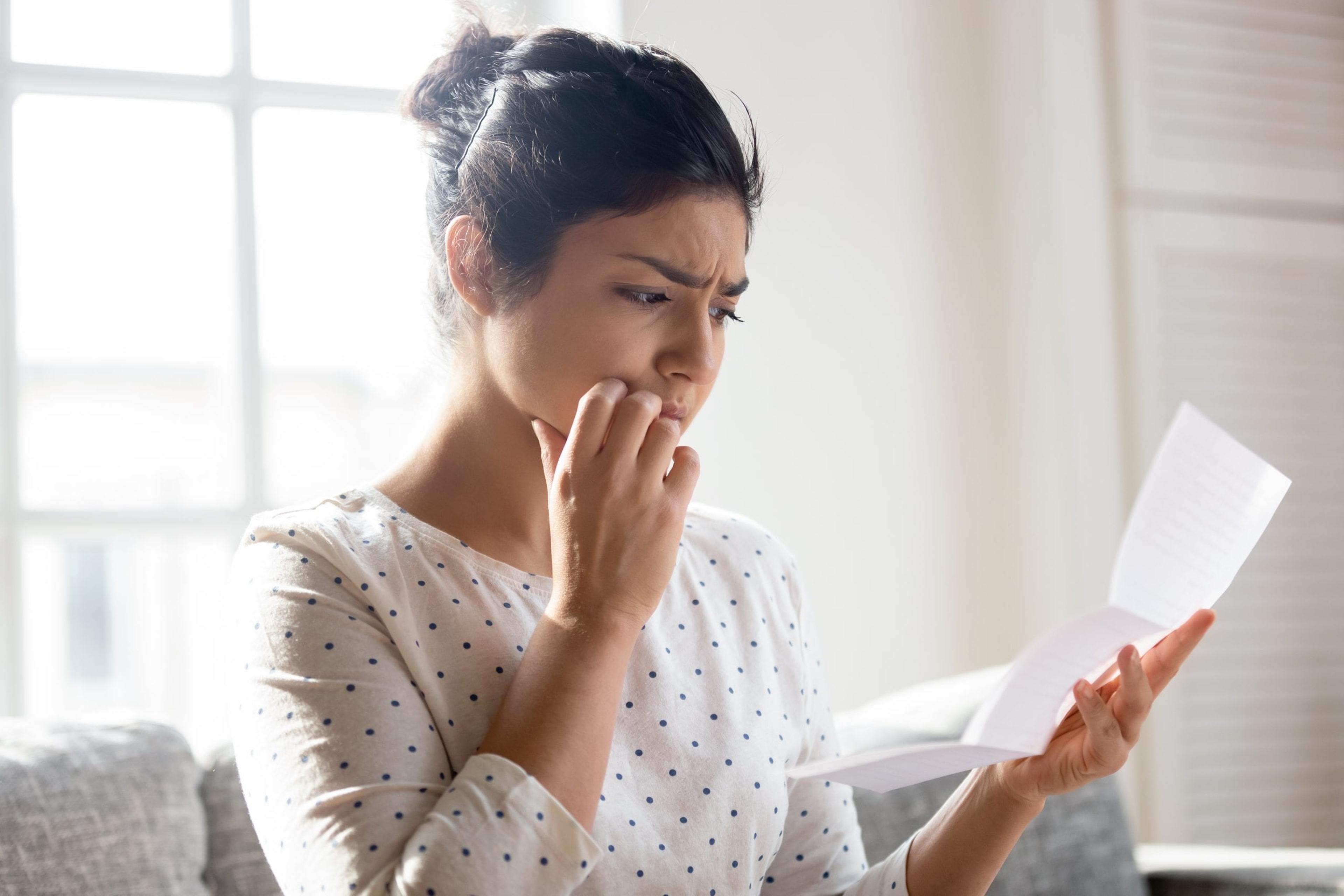 Woman looking at a bill with confusion