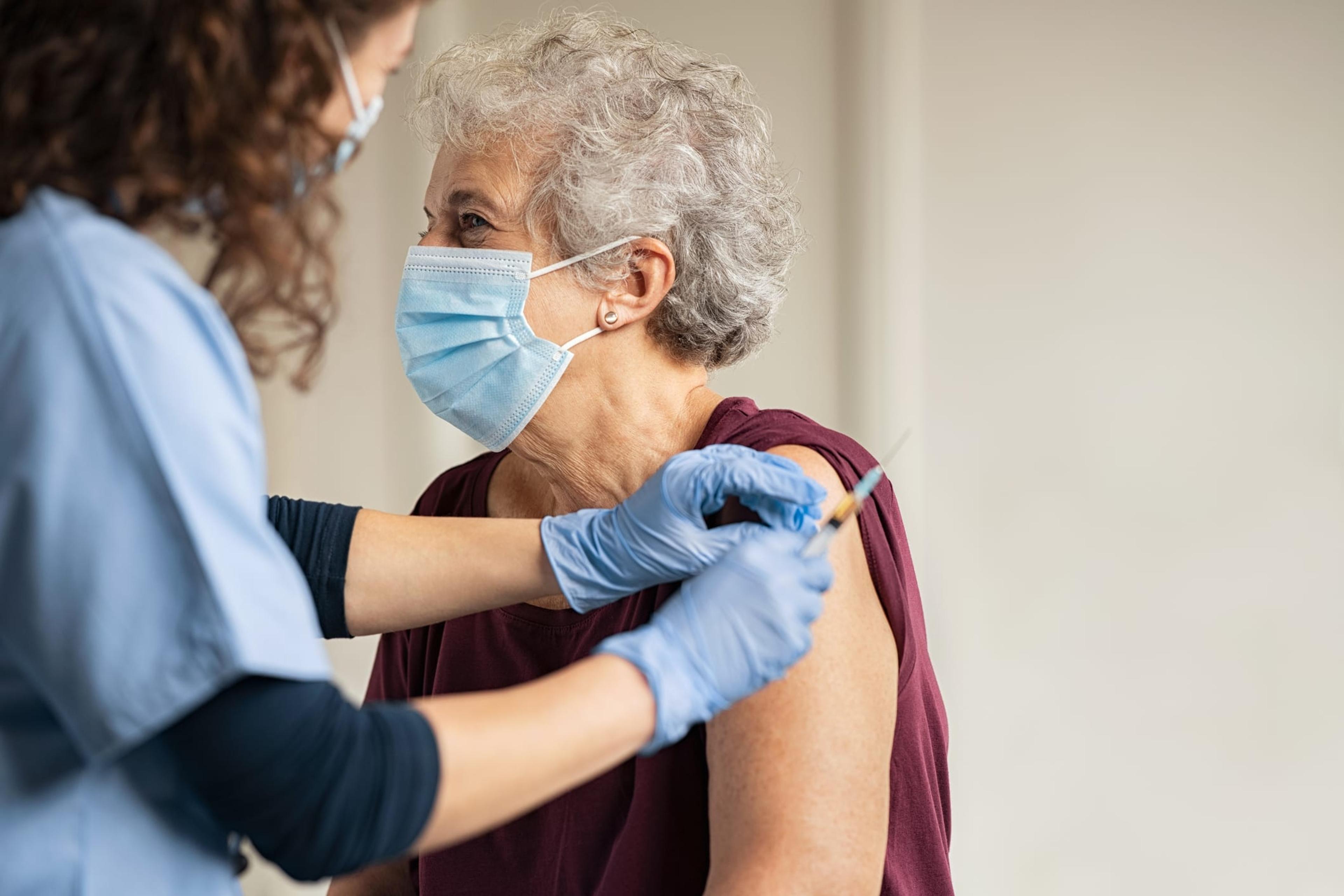 Older woman receives a vaccine in her arm