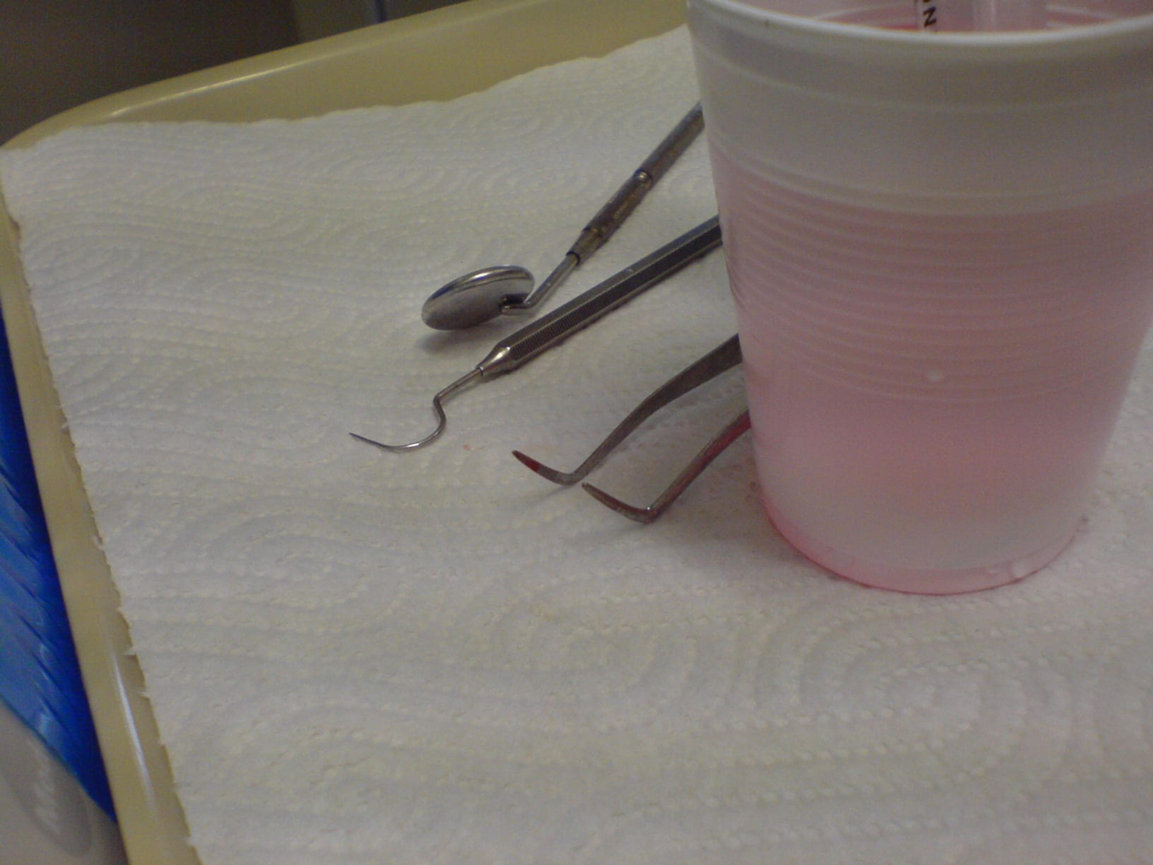 Dental tools next to a plastic cup