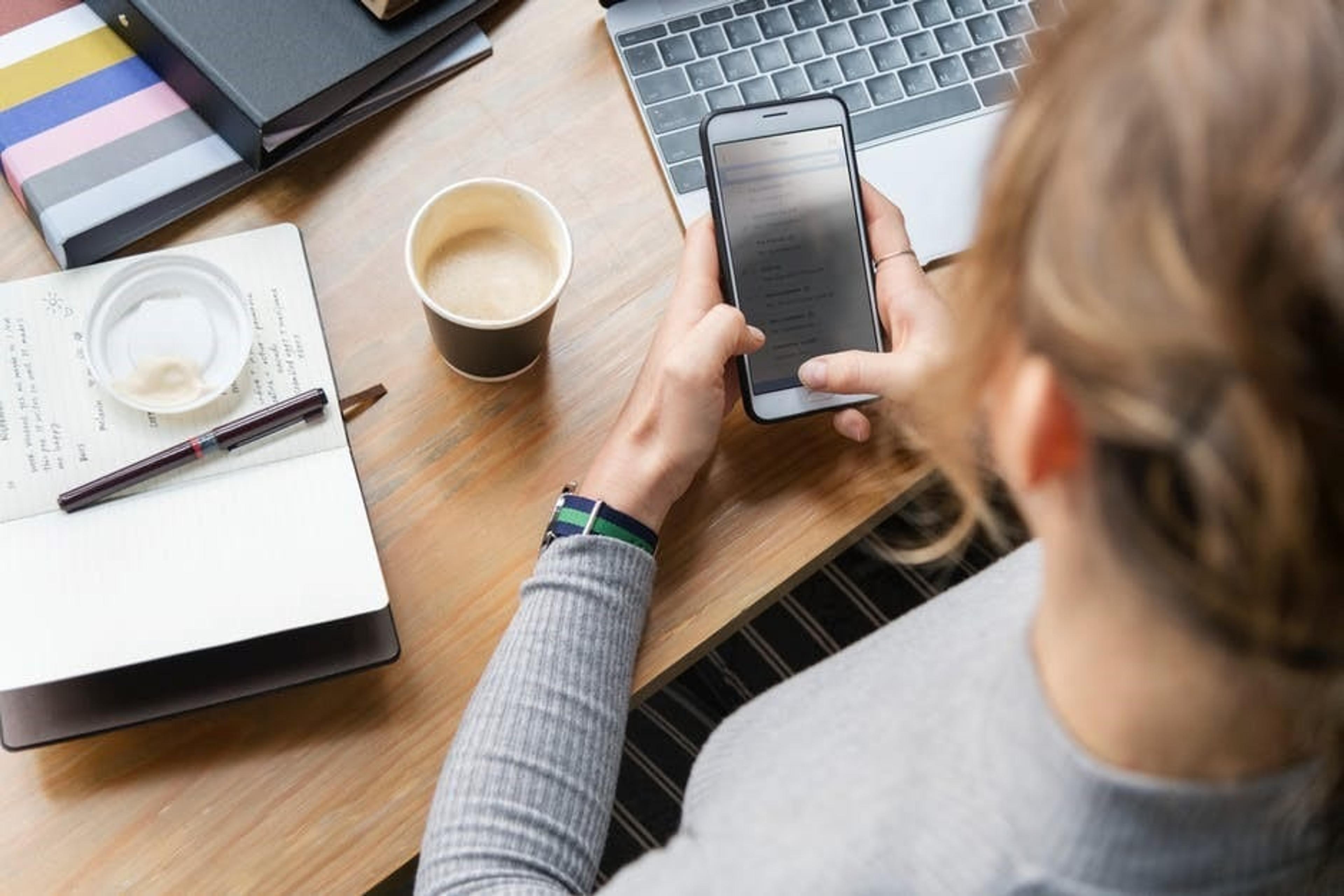 Woman at desk using cellphone