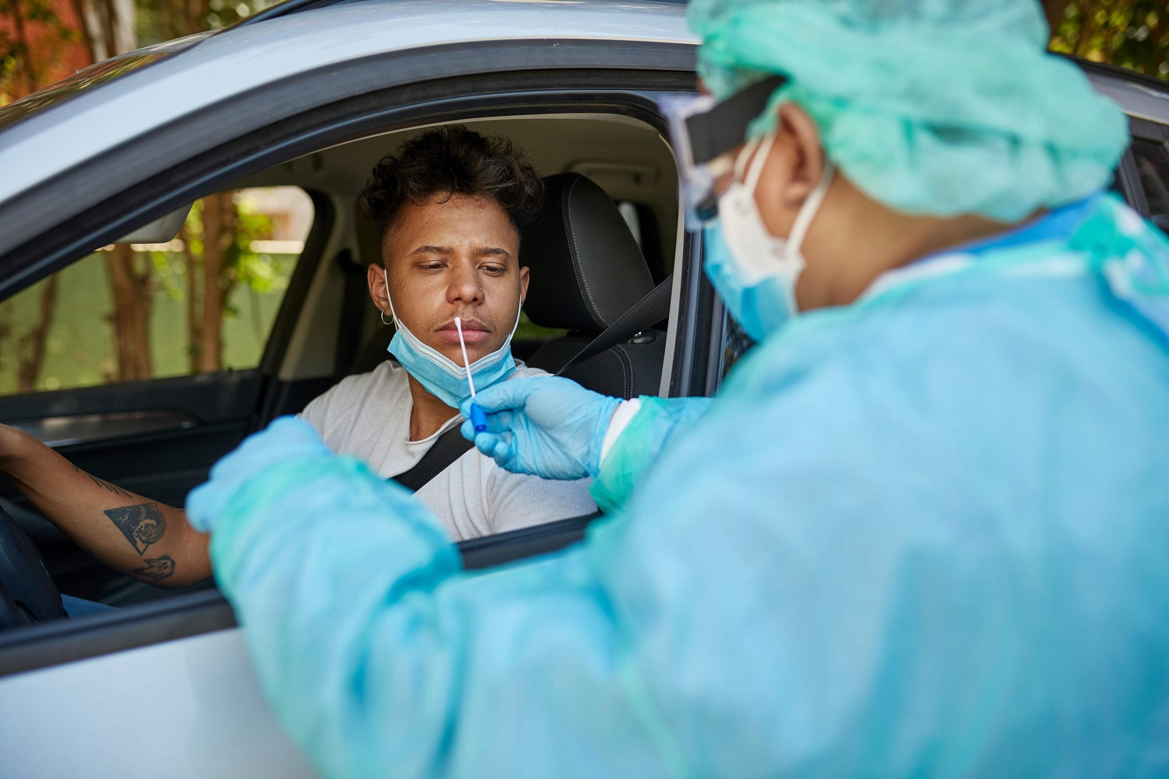 Young man getting a COVID test at a drive-up event