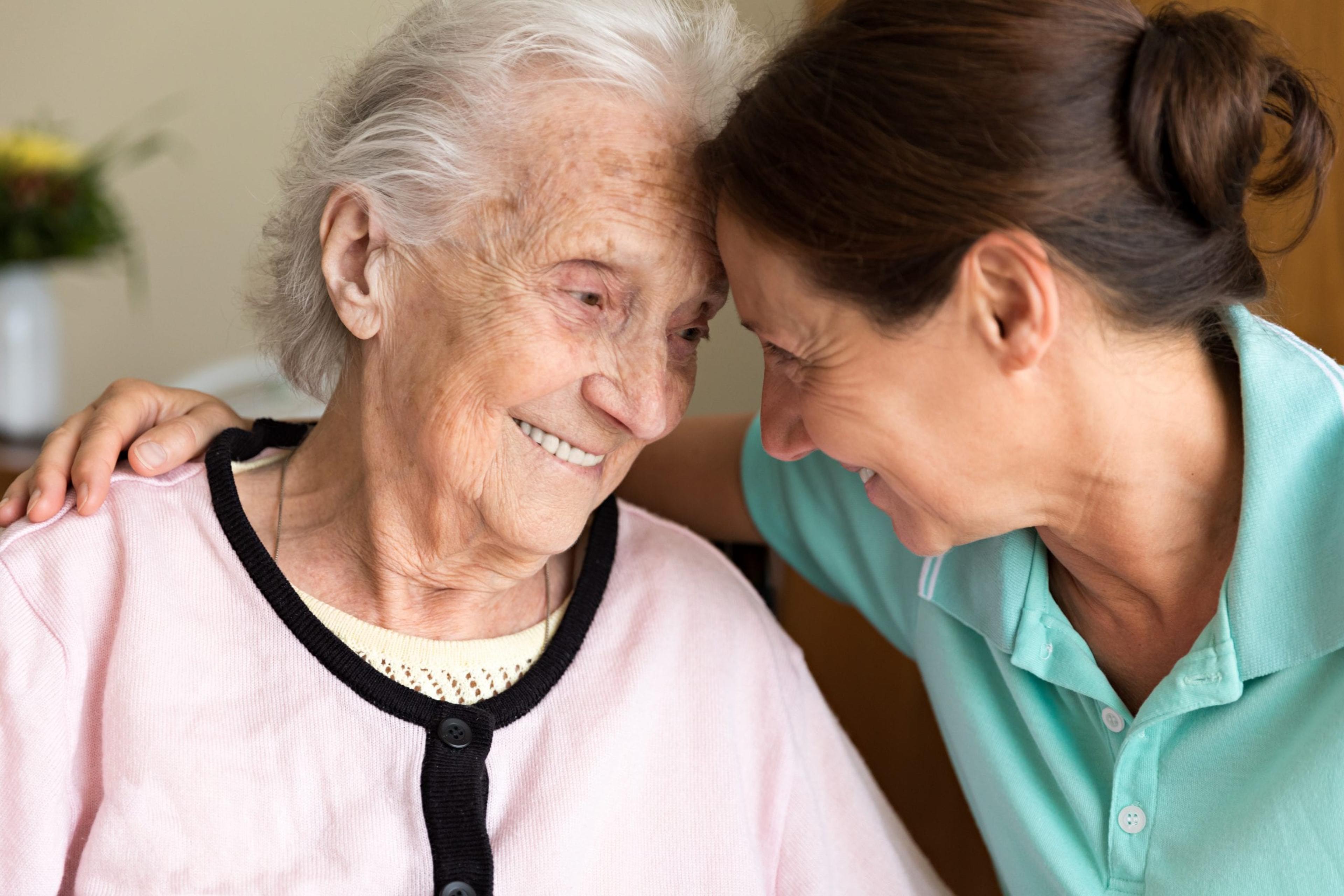 An older adult with her caregiver.