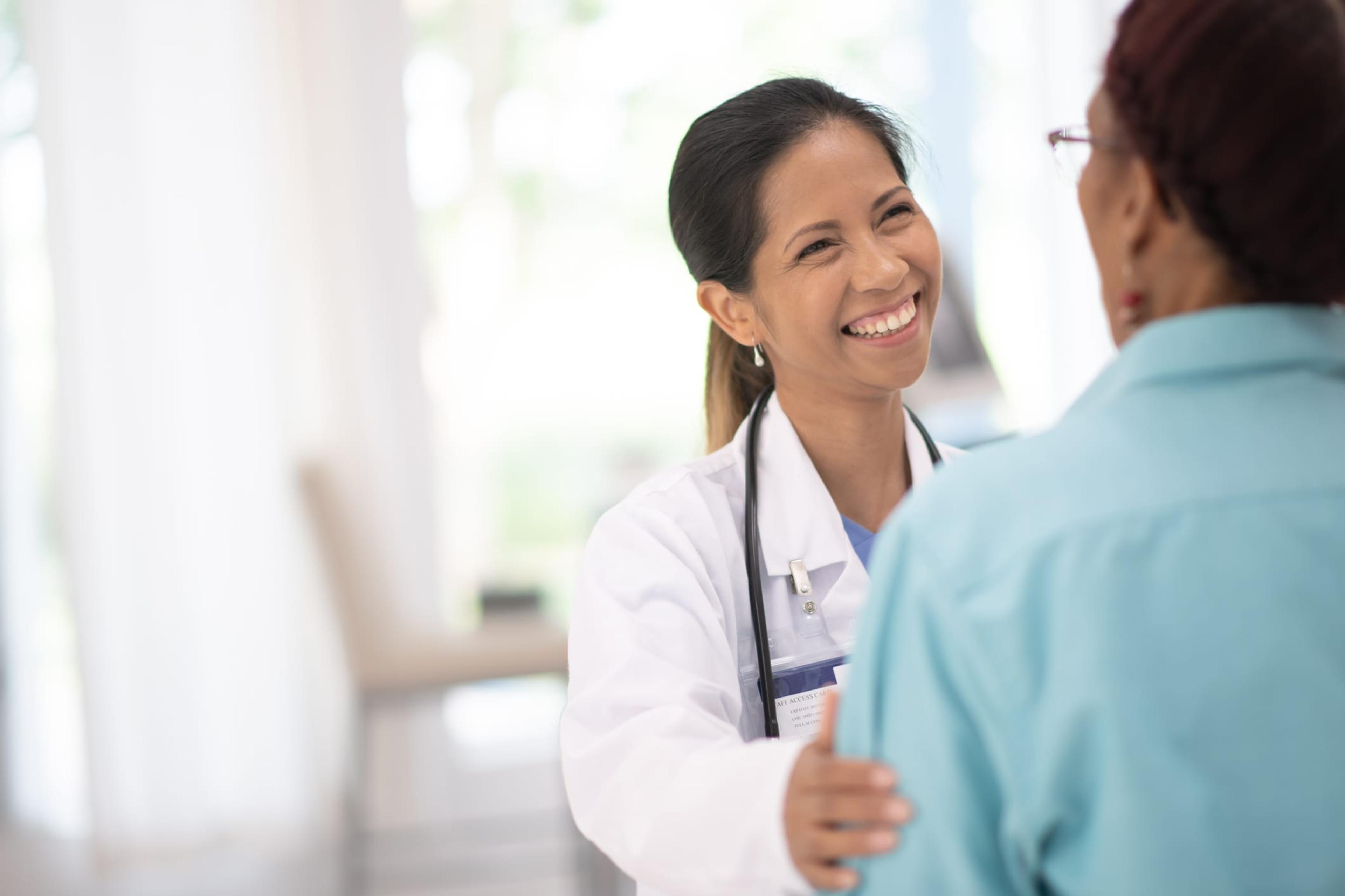 Female doctor smiles as she meets with her patient