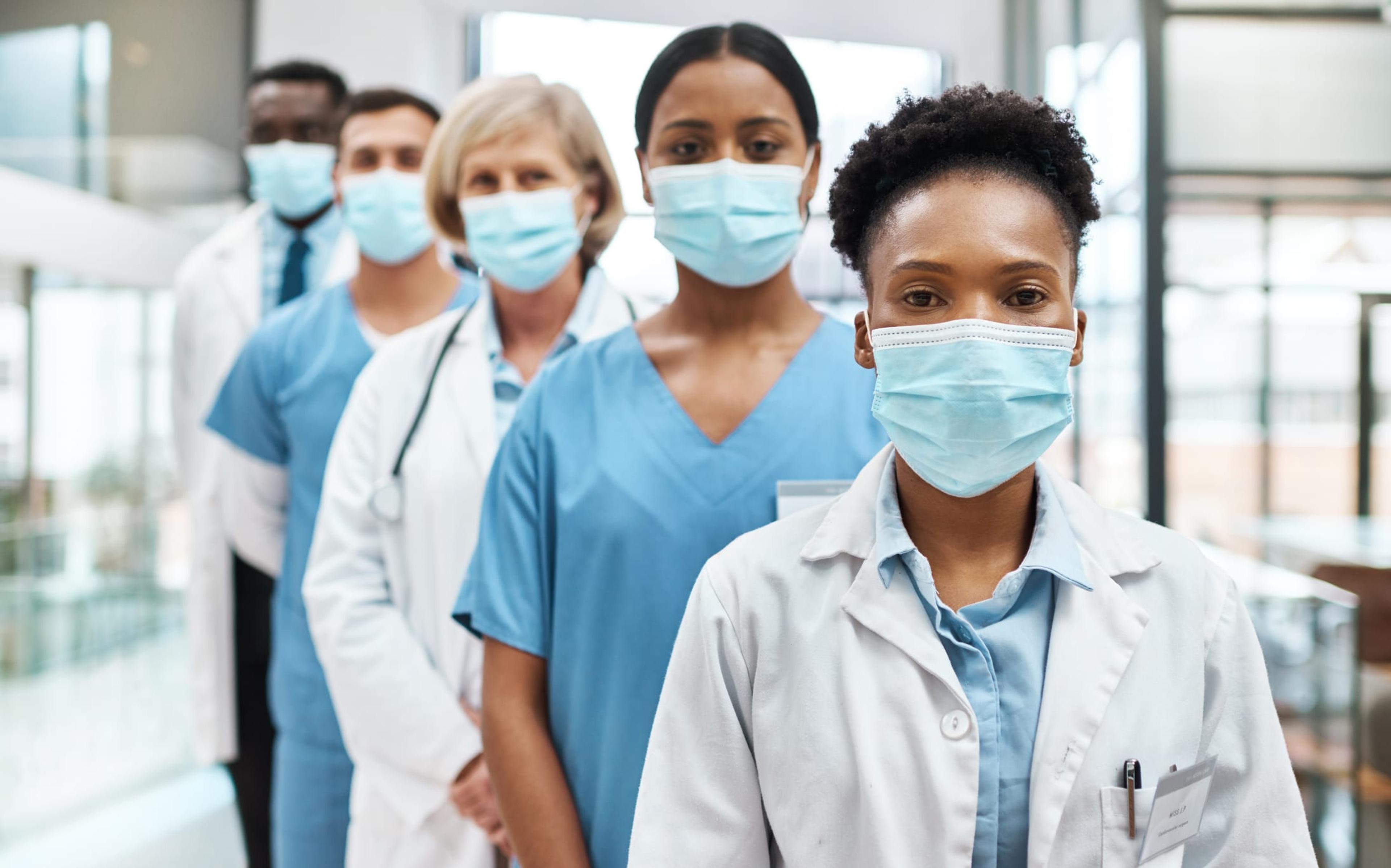 Portrait of a group of medical practitioners wearing face masks while standing together in a hospital