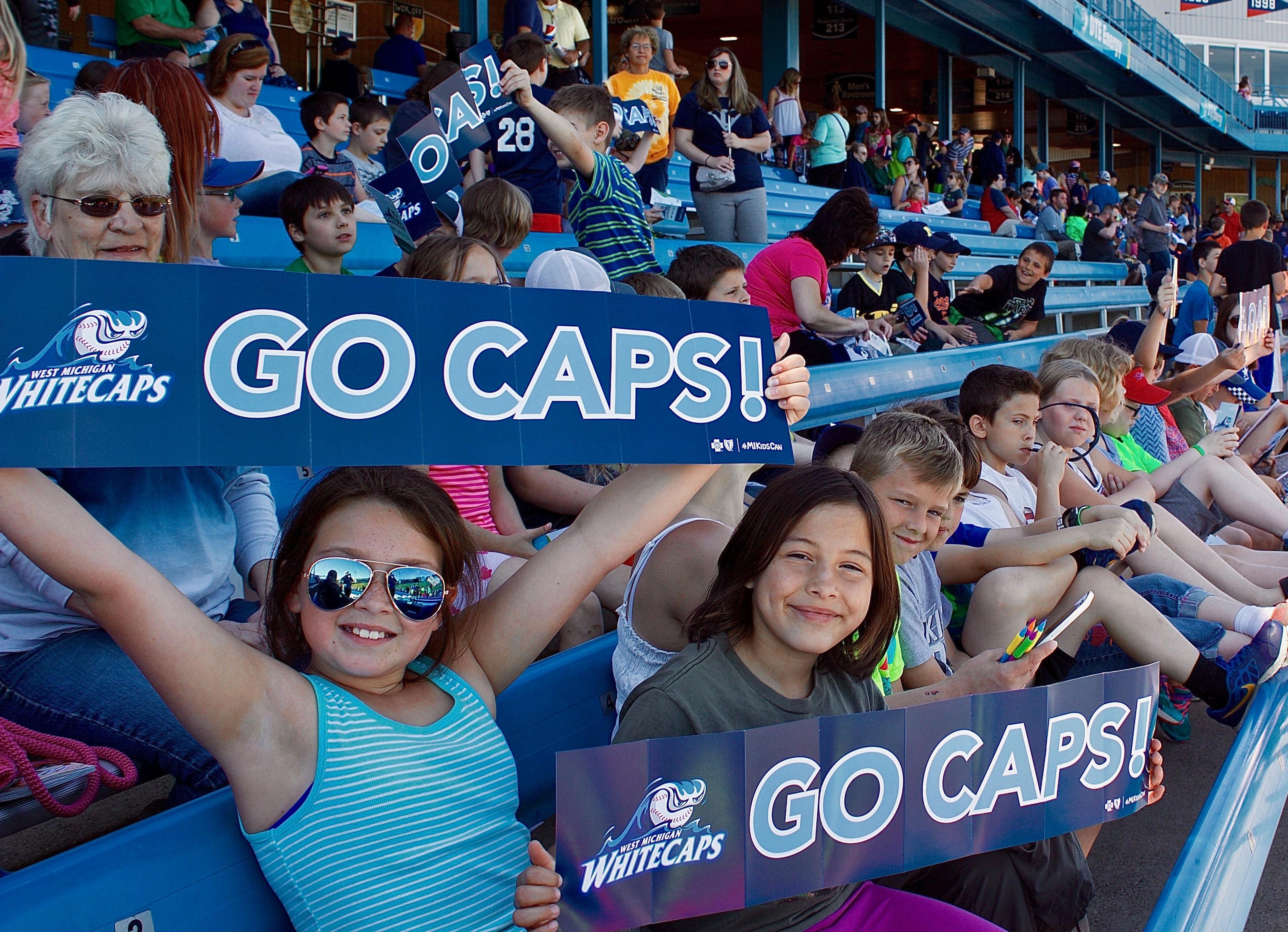 Students hold "Go Caps!" signs at one of last year's Whitecaps School Days games.