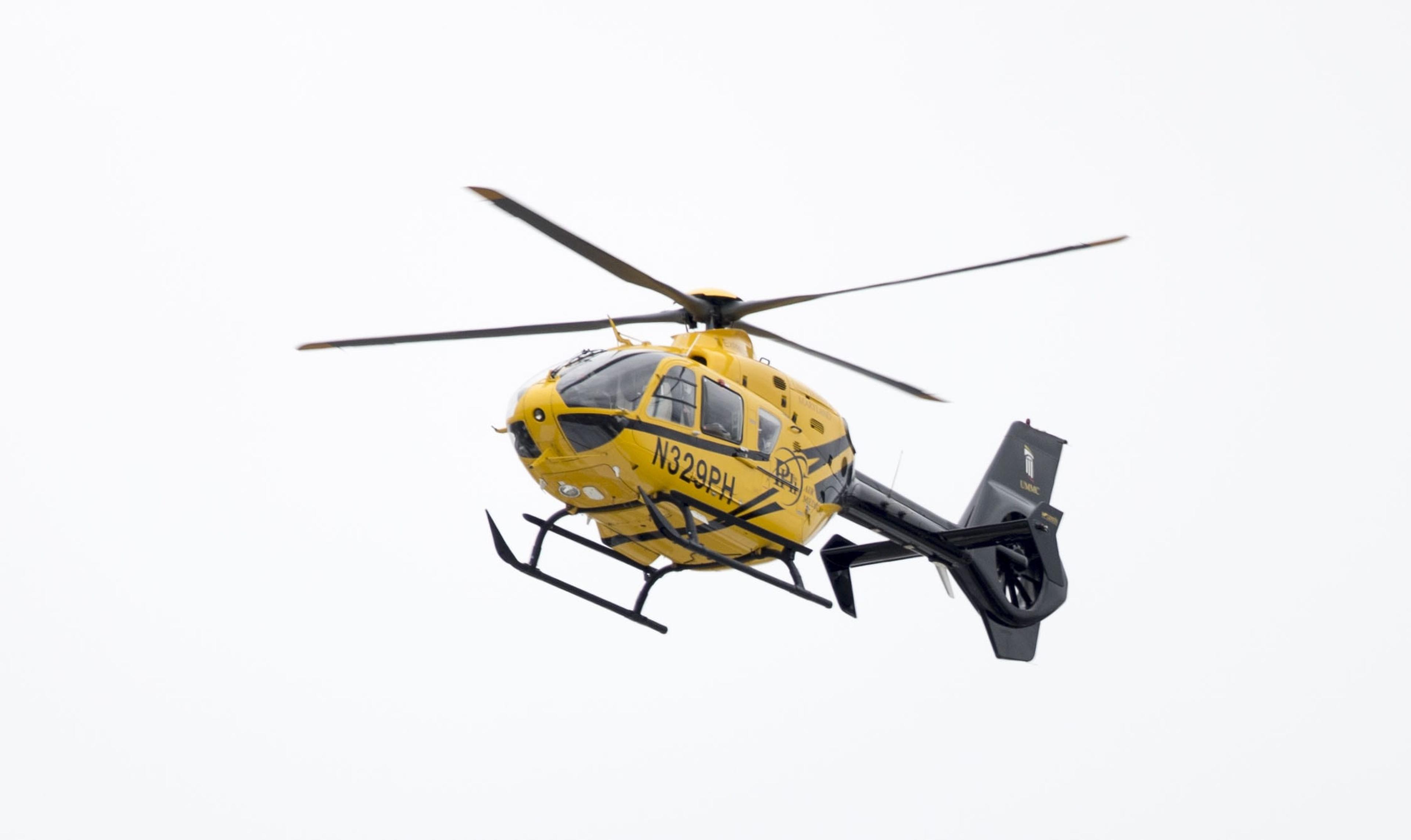 A yellow medical center helicopter in the air